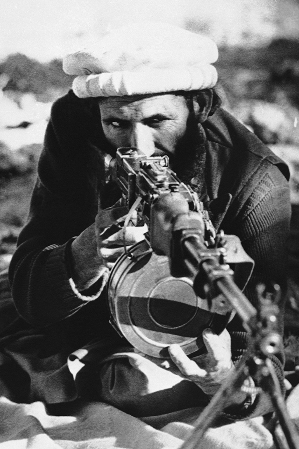 An Afghan rebel takes aim with a captured Soviet-made light machine gun. 