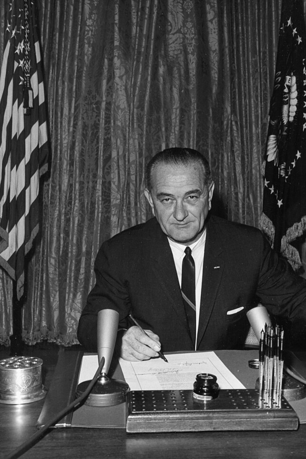 <p>President Lyndon B. Johnson signs the Gulf of Tonkin Resolution in the White House East Room, August 10, 1964.</p>
