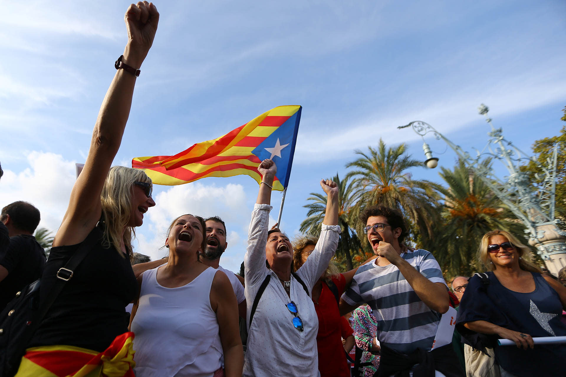People shout slogans as a separatist Catalonian flag is waved at a rally in support of independence in Barcelona