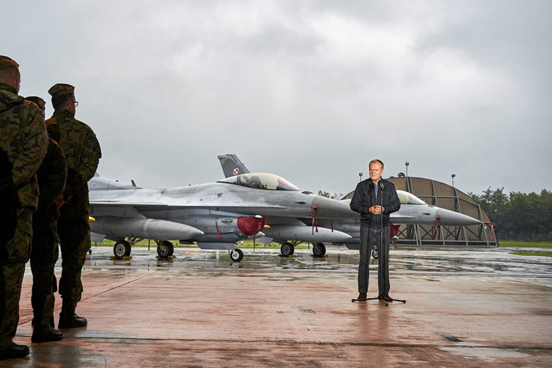 <p>Polish service members listen as Prime Minister Donald Tusk stands in front of fighter jets as he holds a press conference regarding the threat posed by Russian drones in Polish airspace at the 32nd Tactical Air Base in Lask, Poland, September 11, 2025. </p>
