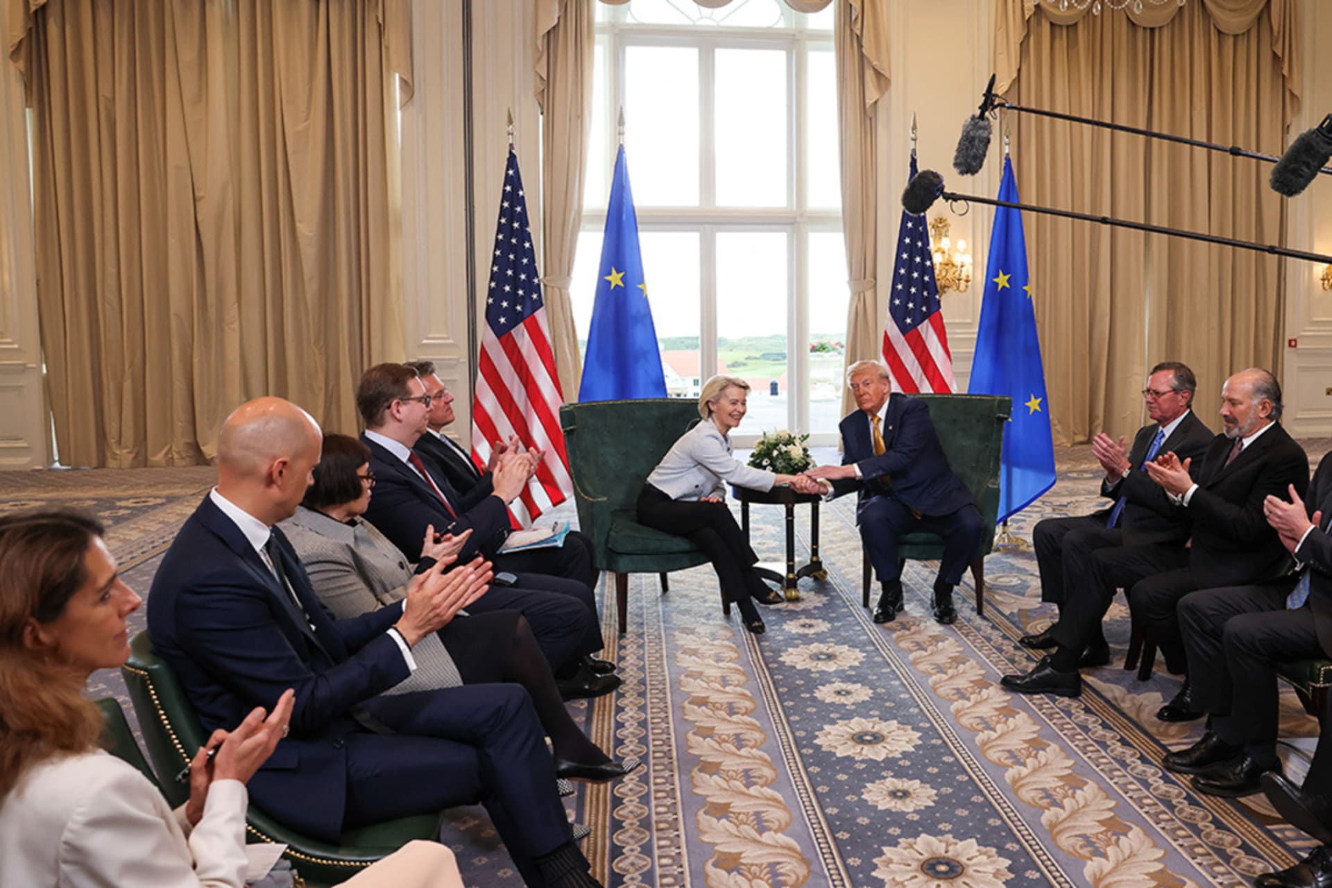 <p>U.S. President Donald Trump shakes hands with European Commission President Ursula von der Leyen as U.S. officials clap after an announcement of a trade deal between the United States and EU, in Turnberry, Scotland, on July 27.</p>
