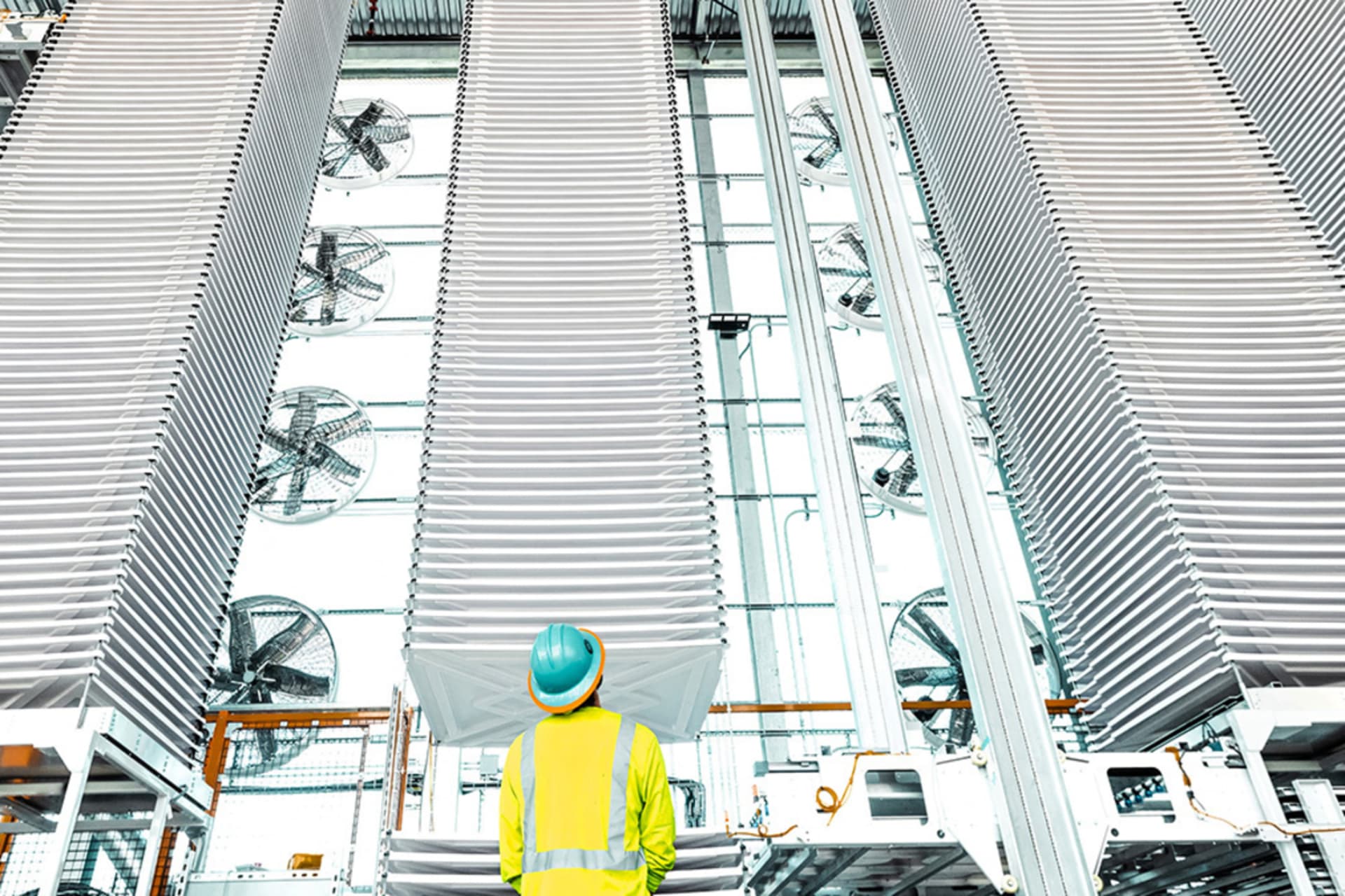 <p>A person looks at stacks of trays holding treated limestone, used to absorb CO2 form the air, at a plant in Tracy, California,.</p>
