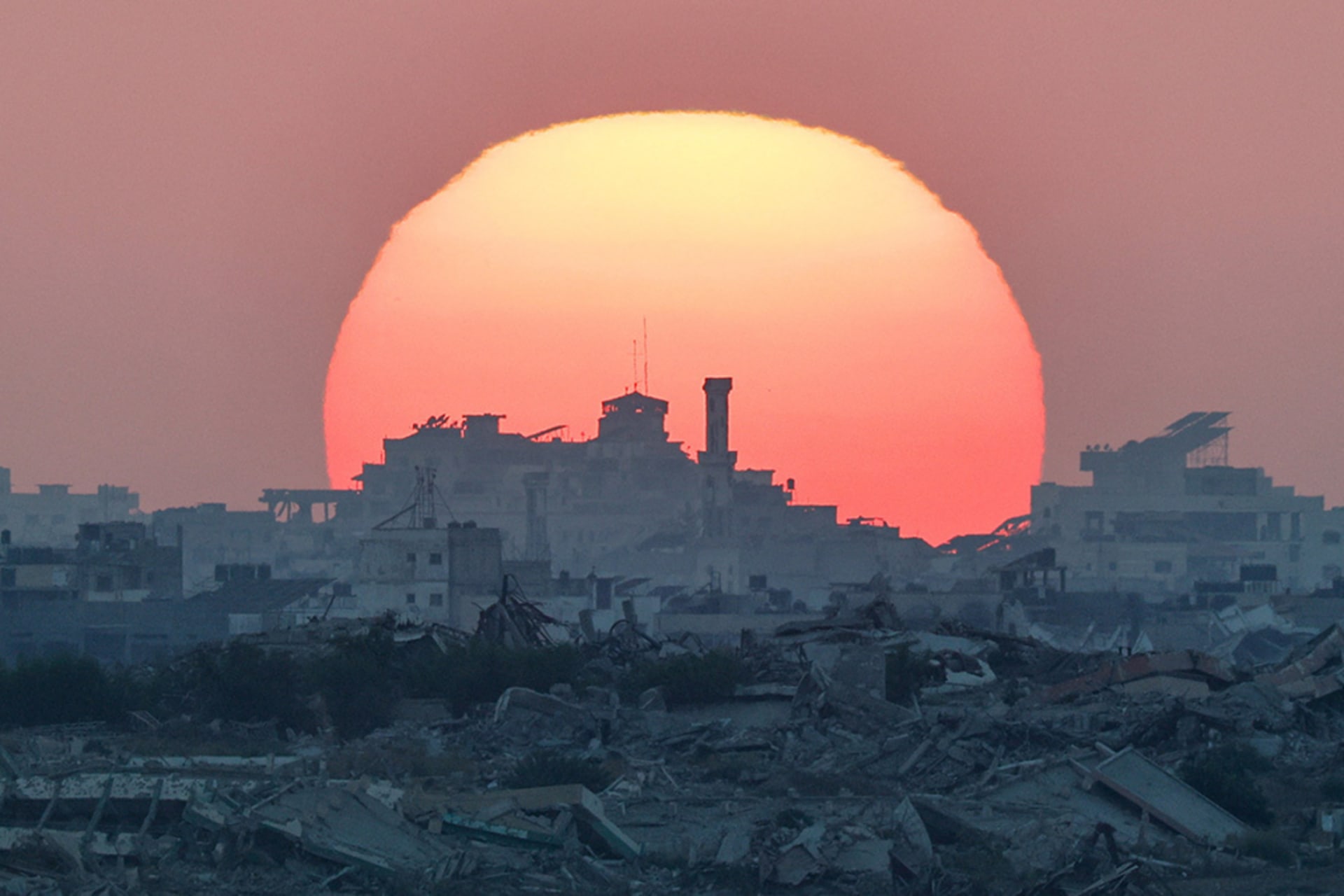 <p>The sun sets over Gaza, as seen from the Israeli side of the border between Gaza and Israel, August 19, 2025.</p>
