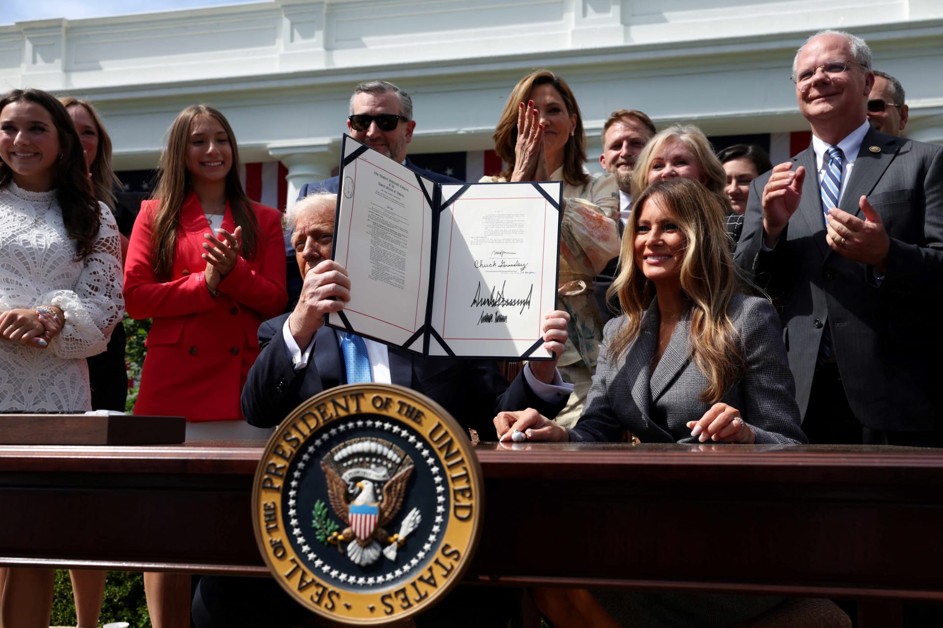 <p>U.S. President Donald Trump shows the signed bill during the ceremony for the Take it Down Act, in the Rose Garden of the White House in Washington, D.C., U.S., May 19, 2025. </p>
