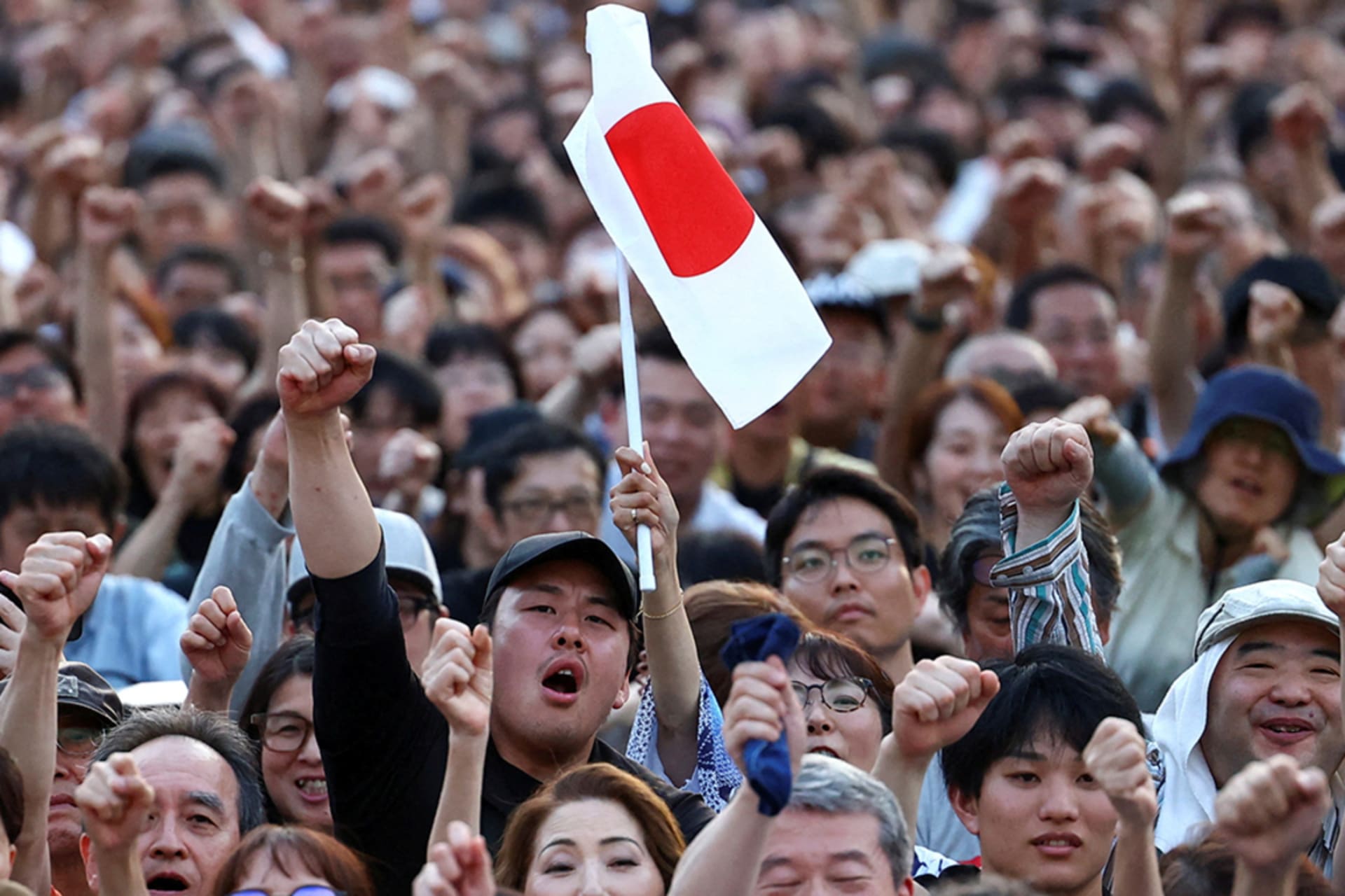 <p>Sanseitō supporters raise their fists during the party’s election campaign tour for the July 20 upper house election, at Shiba Park in Tokyo, Japan, July 19, 2025.</p>
