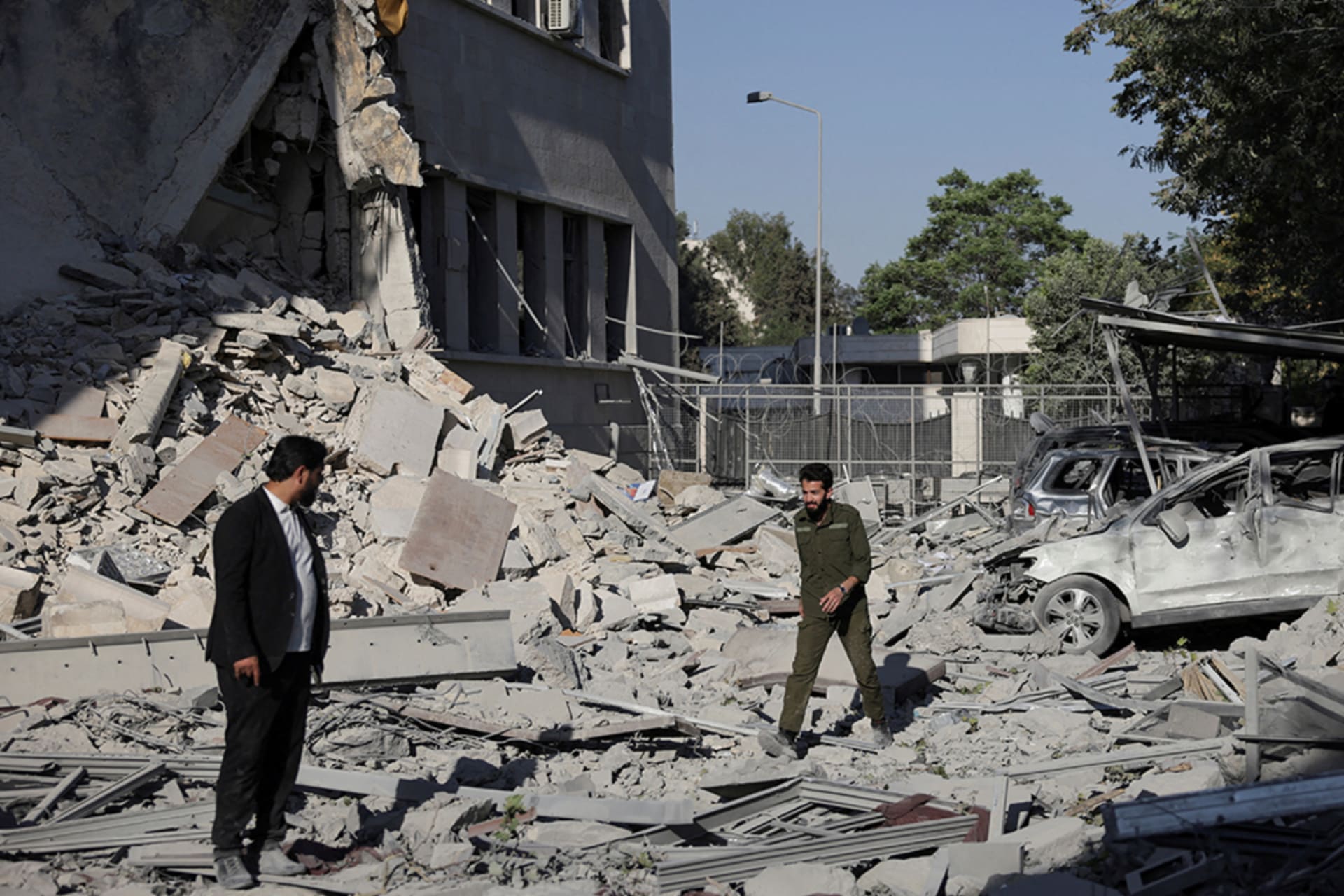 <p>Men walk among debris, after powerful airstrikes shook Damascus, July 16, 2025.</p>
