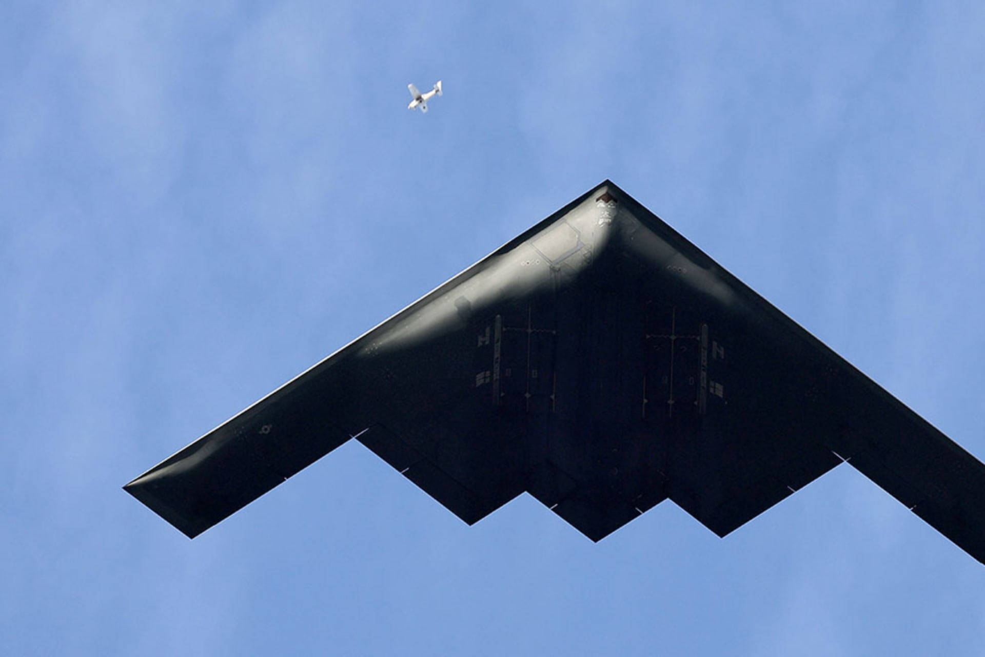 <p>A small plane is dwarfed by a B-2 Stealth Bomber flying over Pasadena, California, January 1, 2025.</p>
