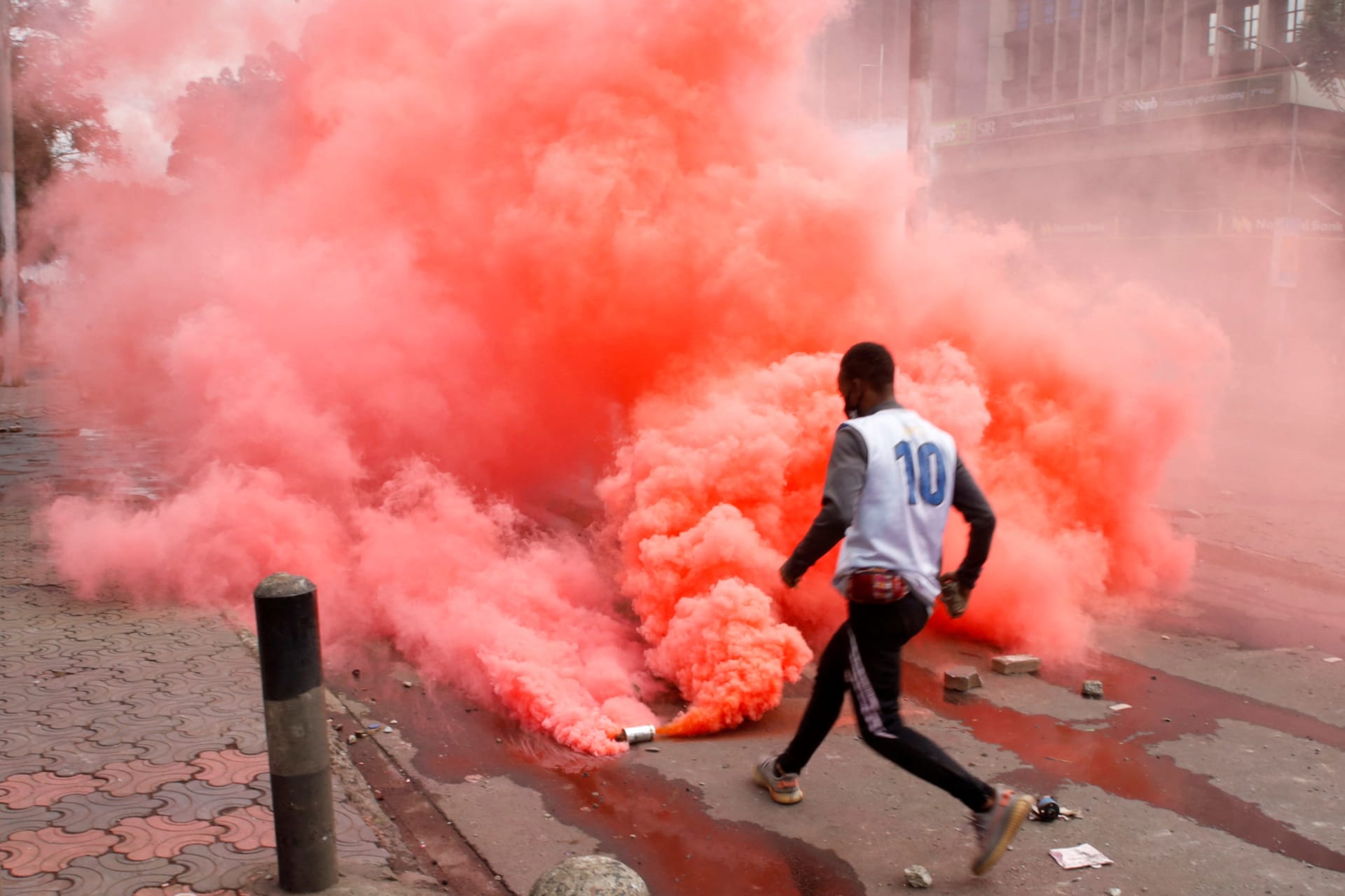<p>A protester prepares to throw back a colored teargas canister lobbed by riot police officers during demonstrations to mark the first anniversary of the deadly 2024 anti-government protests in Nairobi, Kenya on June 25, 2025.</p>
