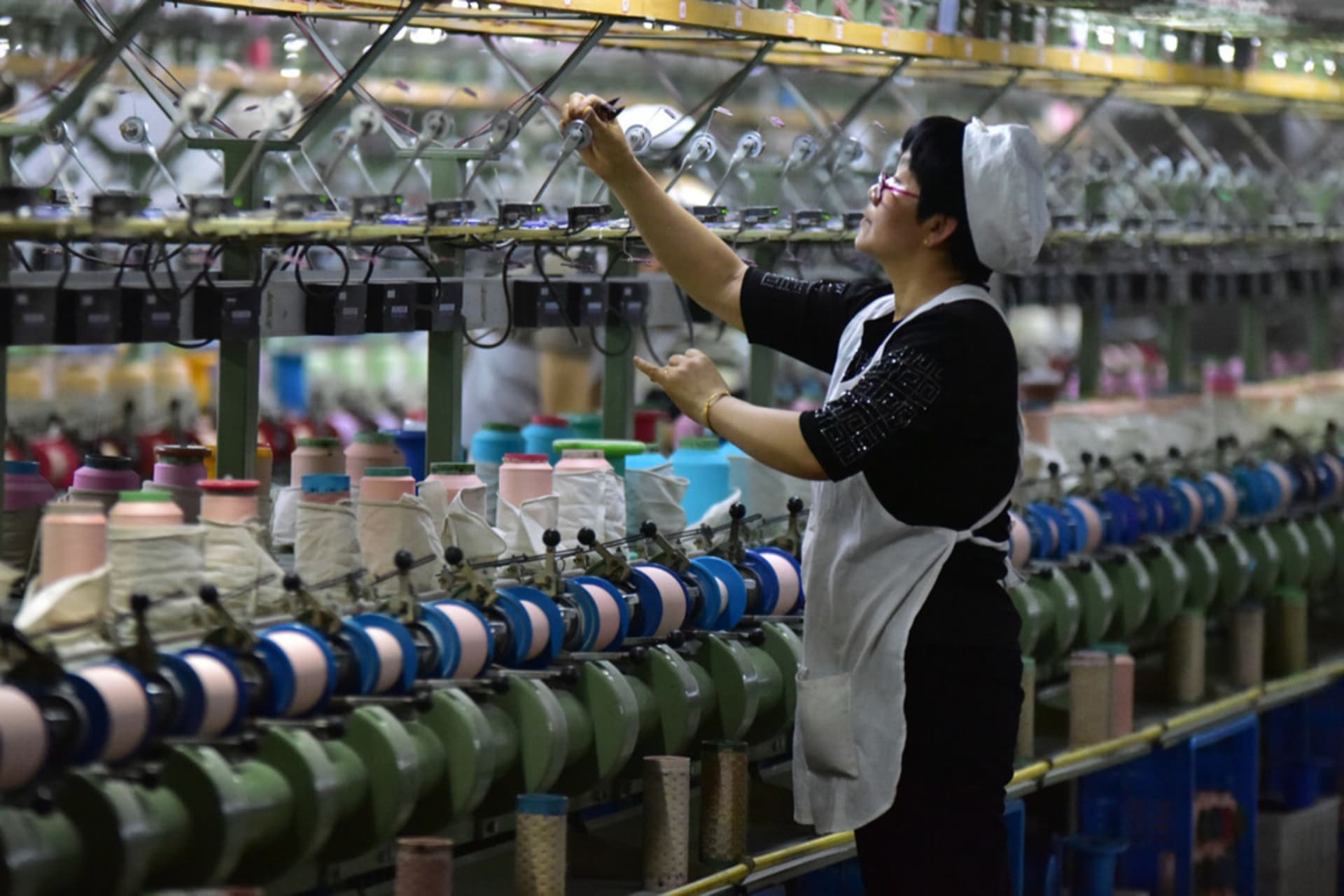<p>A worker checks a machine at a factory that produces silk cloth in Fuyang, China.</p>
