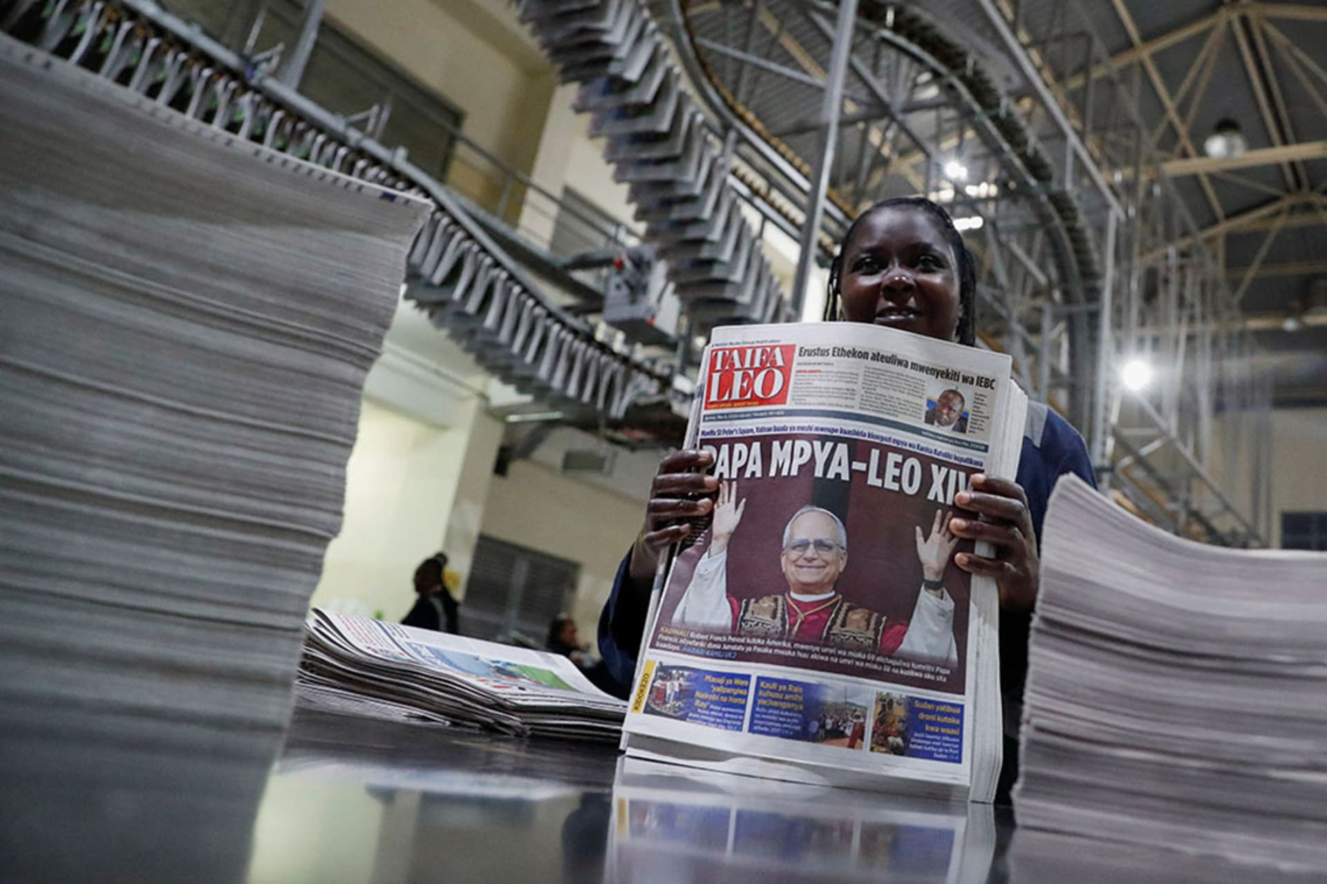 <p>A worker in Nairobi, Kenya, holds a newspaper with a picture of the newly elected Pope Leo XIV.</p>
