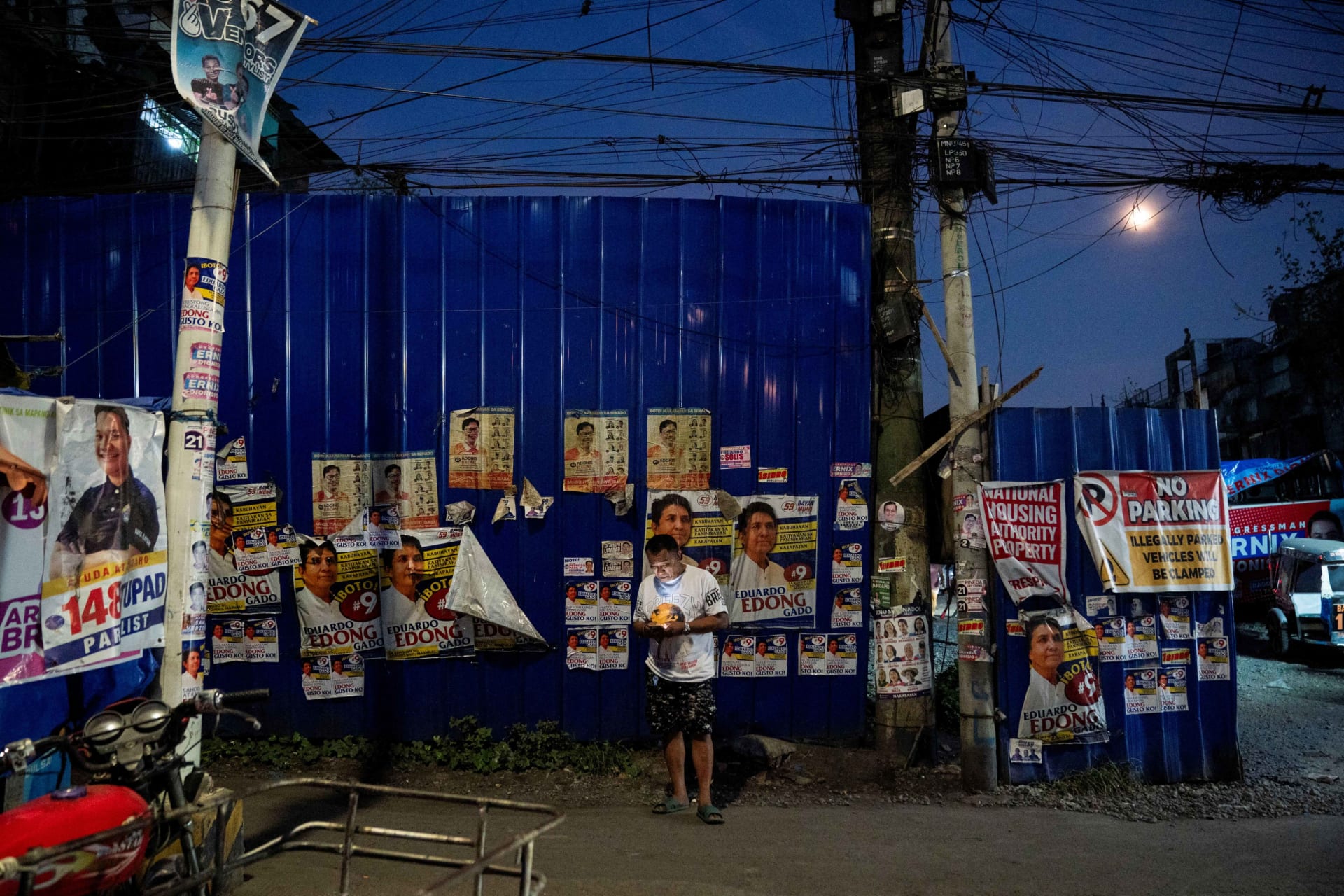 <p>A man stands in front of a wall with campaign posters put up, a day before the May 12 midterm elections, in Manila, Philippines, on May 11.</p>
