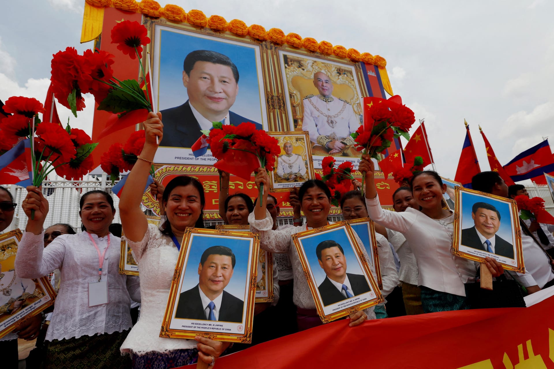 <p>People react while holding pictures of Chinese President Xi Jinping and Cambodia’s King Norodom Sihamoni as President Xi Jinping arrives for a two-day visit to Cambodia, at Phnom Penh International Airport on April 17, 2025.</p>
