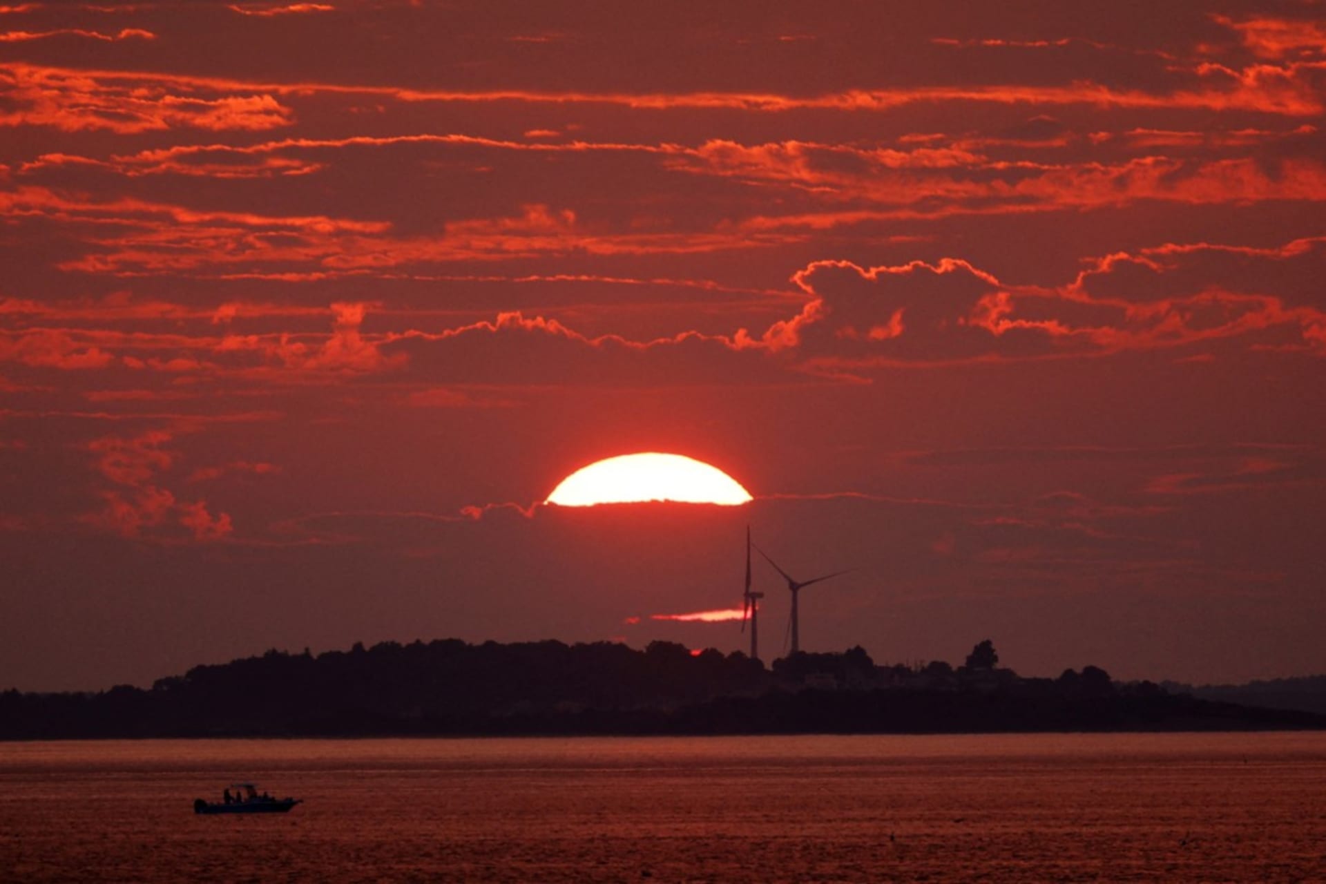<p>The sun sets behind a pair of wind turbines in Newburyport, Massachusetts, on August 25, 2024. </p>
