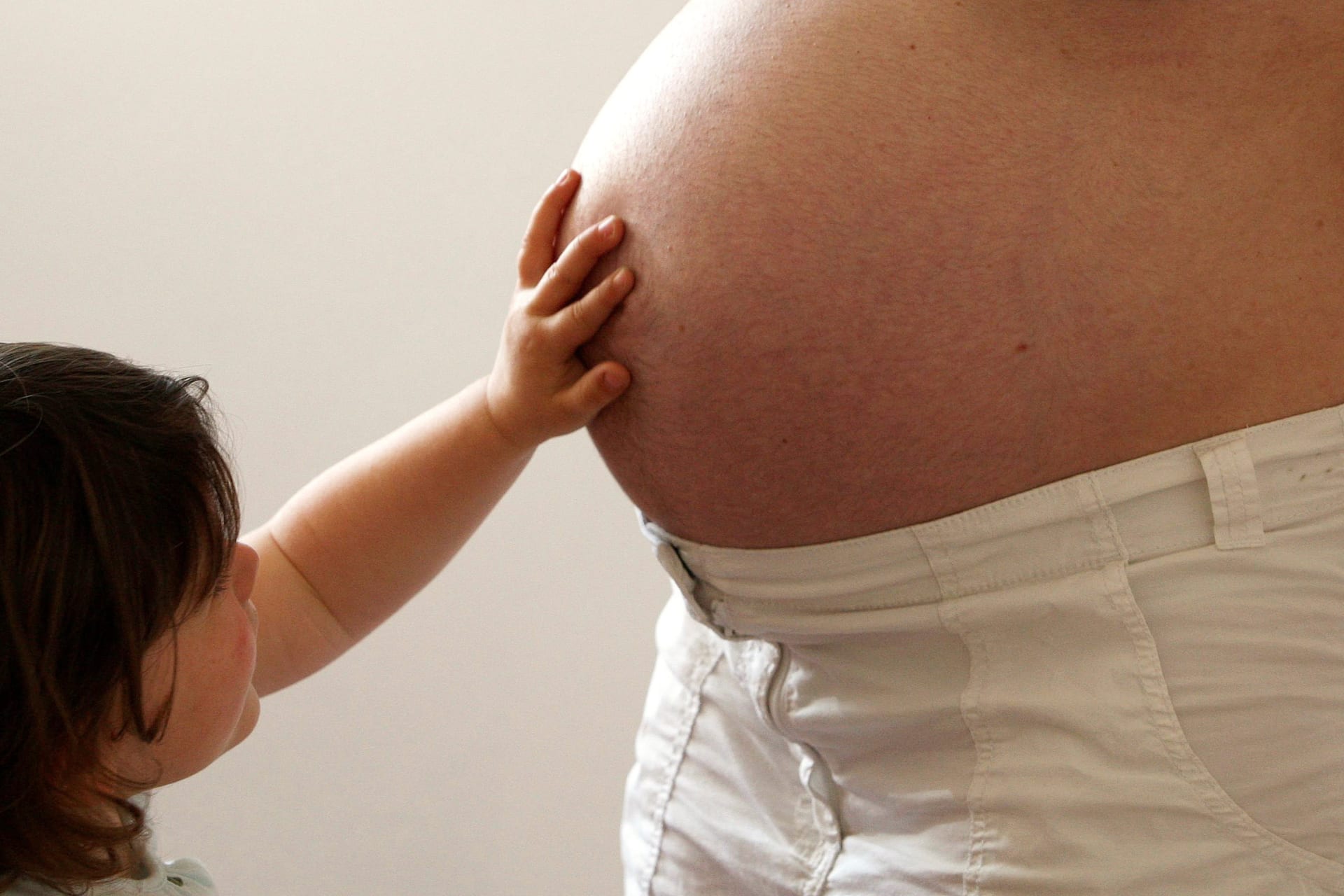 <p> A child touches her pregnant mother’s stomach at the last stages of her pregnancy in Bordeaux April 28, 2010.</p>

