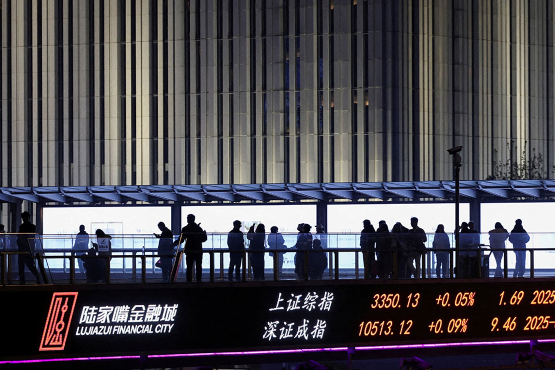 <p>An electronic board shows Shanghai and Shenzhen stock indices as people walk on a pedestrian bridge at the Lujiazui financial district in Shanghai, China April 2, 2025.</p>