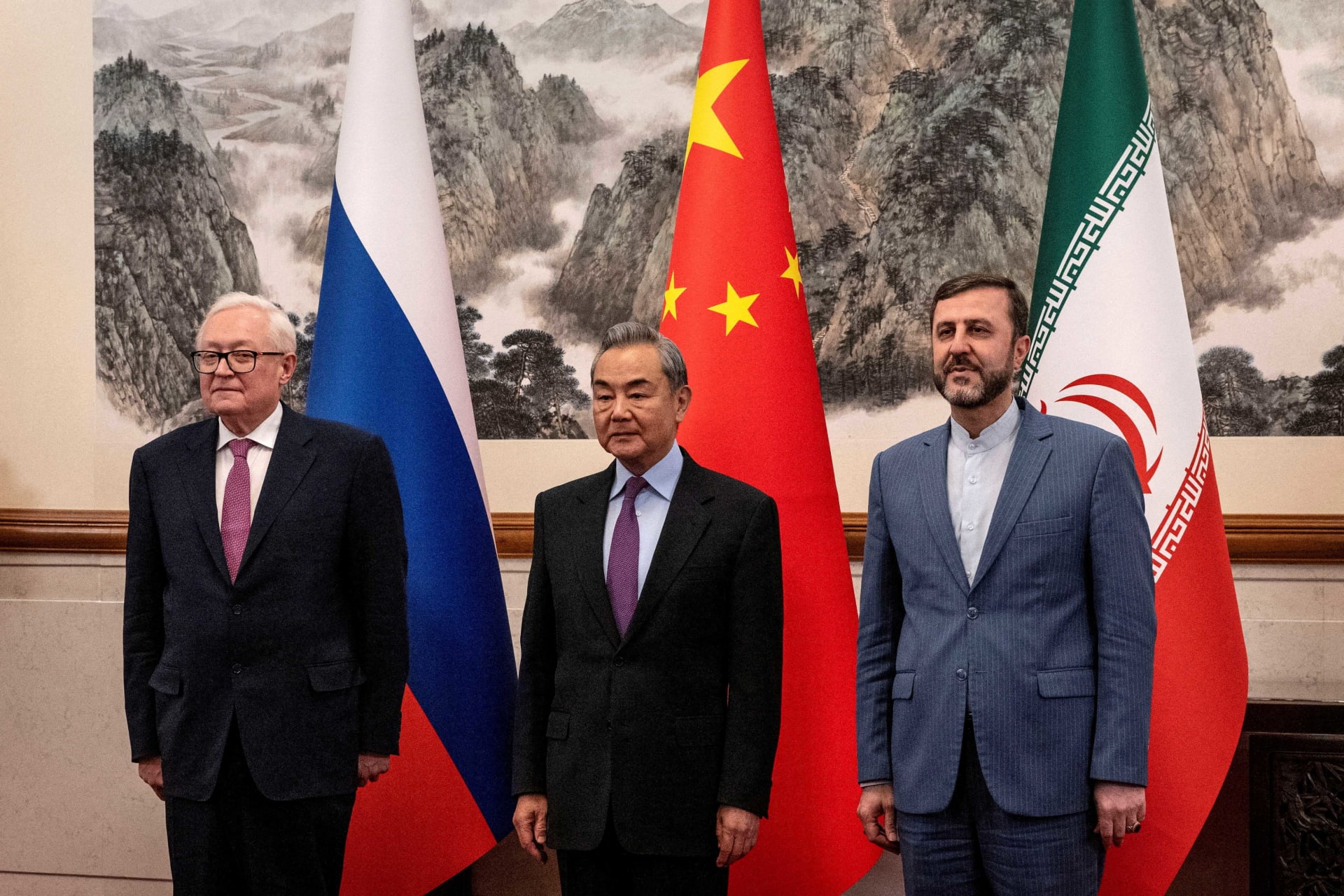 <p>Chinese Foreign Minister Wag Yi, stands with Russian Deputy Foreign Minister Sergey Ryabkov, and Iranian Deputy Foreign Minister Kazeem Gharibabadi, before a meeting regarding the Iranian nuclear issue at Diaoyutai State Guest House on March 14, 2025.</p>
