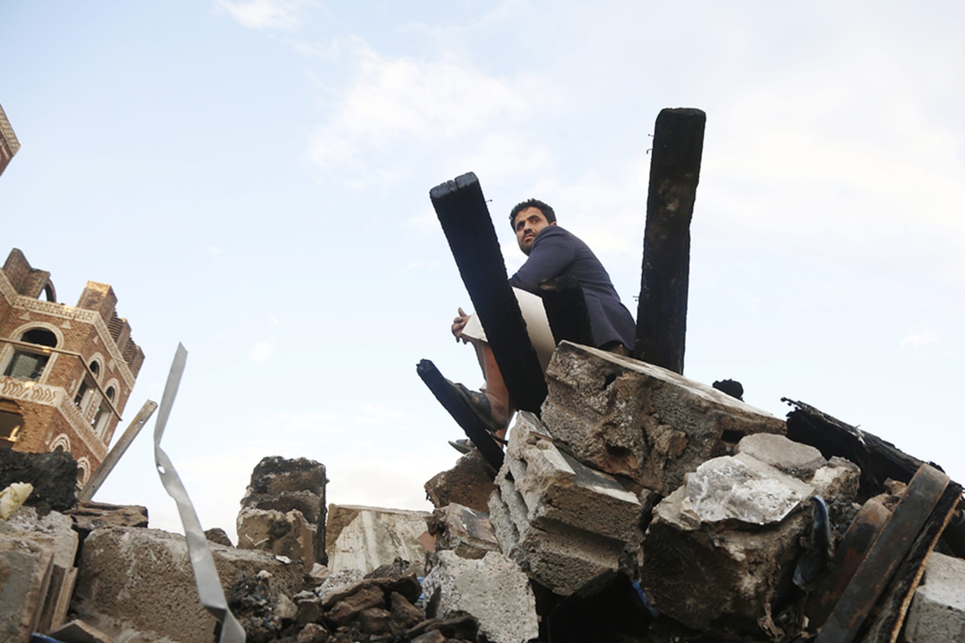 <p>A man sits on the rubble of a building destroyed by U.S. aerial attacks on March 20, 2025, in Sana’a, Yemen.</p>
