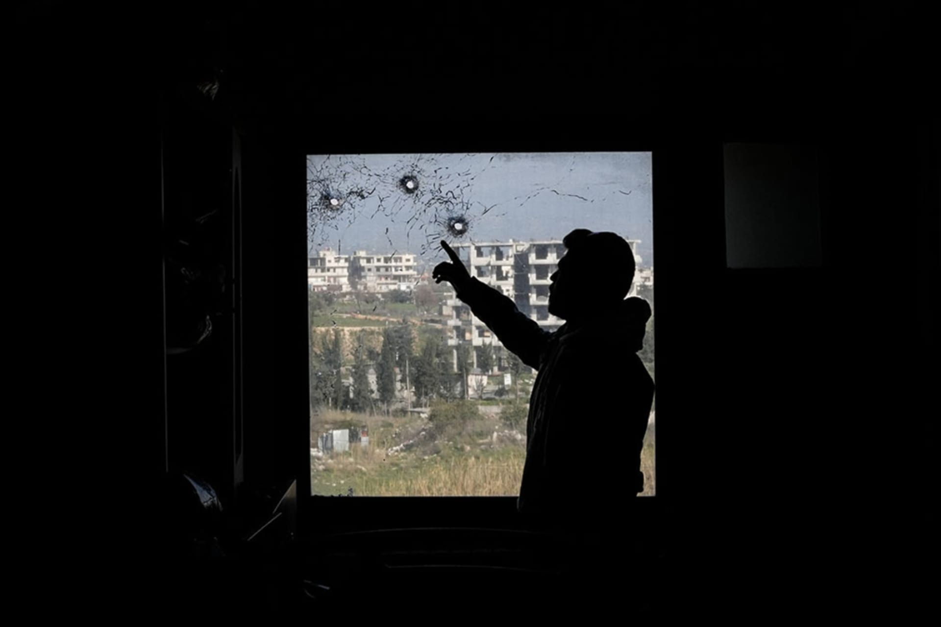 <p>A man points at bullet holes in a window of a hospital following a spate of violence between Syrian security forces and insurgents loyal to ousted President Bashar al-Assad in Syria’s coastal region, on March 10, 2025. </p>
