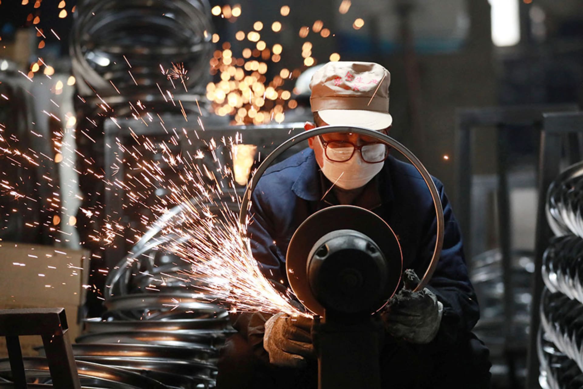 <p>A worker polishes steel bicycle rims at a factory that produces and exports bicycle parts, in Hangzhou, China.</p>
