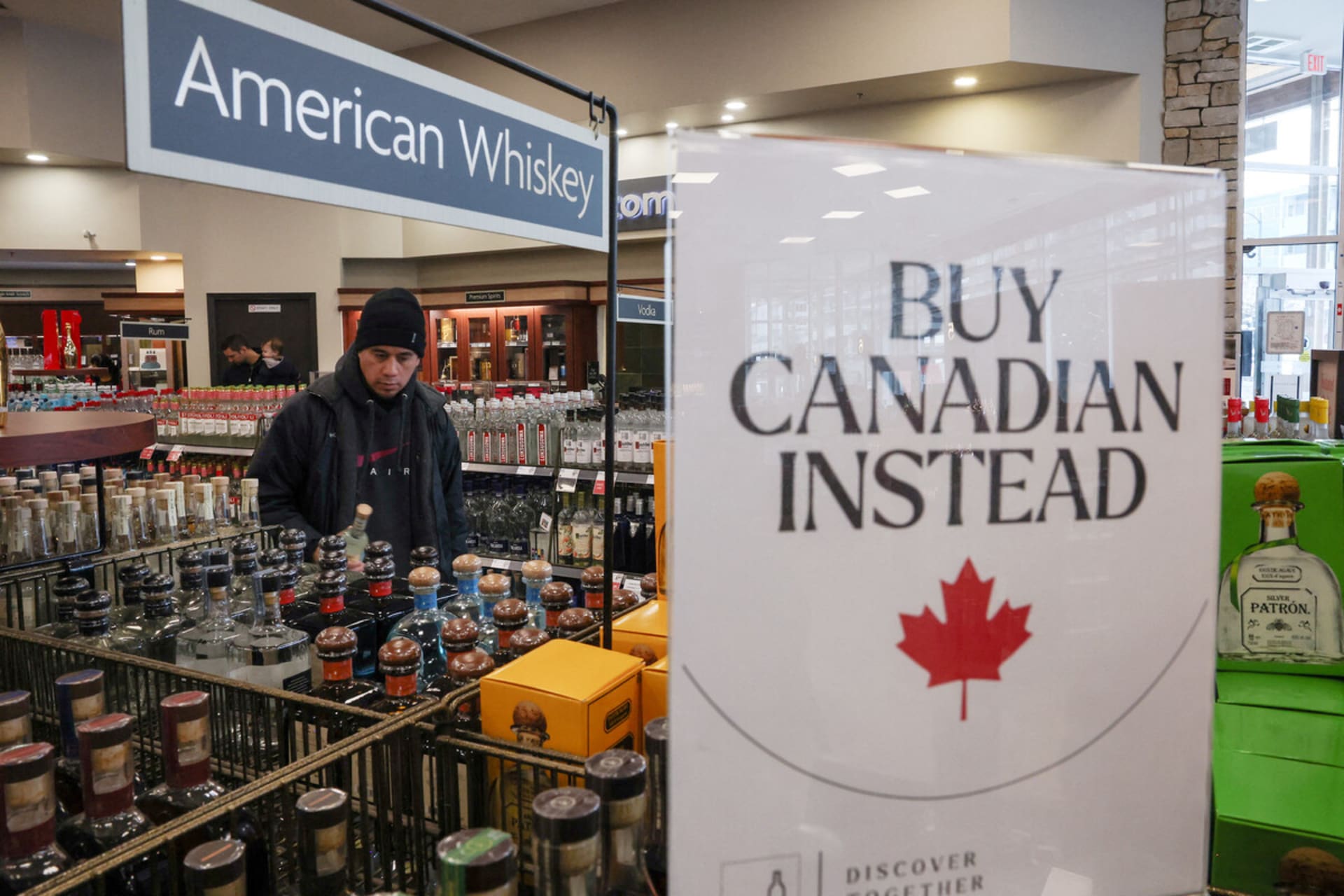 <p>A customer holds a bottle as a sign that reads “Buy Canadian Instead” is displayed after the top five U.S. liquor brands were removed from sale at B.C. Liquor Stores, in Vancouver, British Columbia, Canada.</p>
