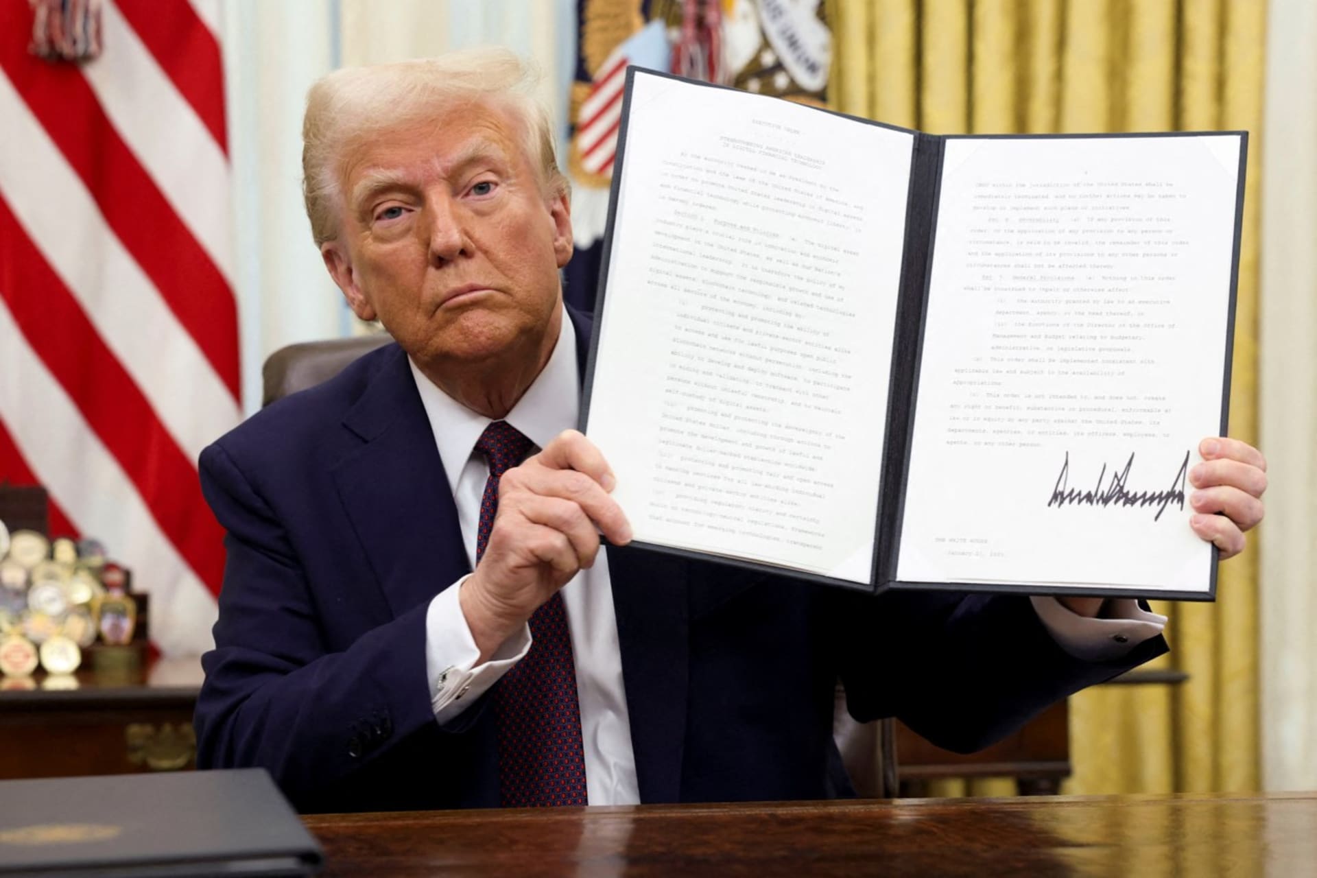 <p>Donald Trump holds a signed executive order on cryptocurrencies in the Oval Office on January 23, 2025. </p>
