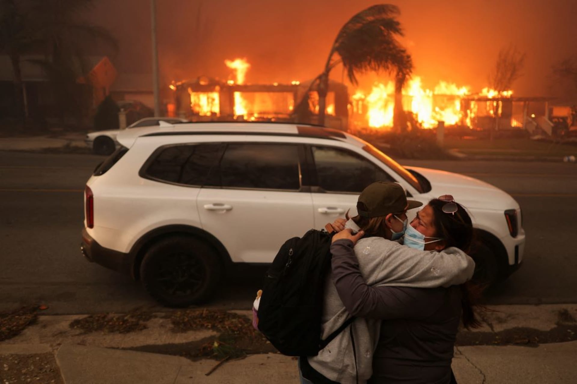 <p>Two people embrace as they evacuate the devastating wildfires in the Los Angeles area, on January 8, 2025.</p>
