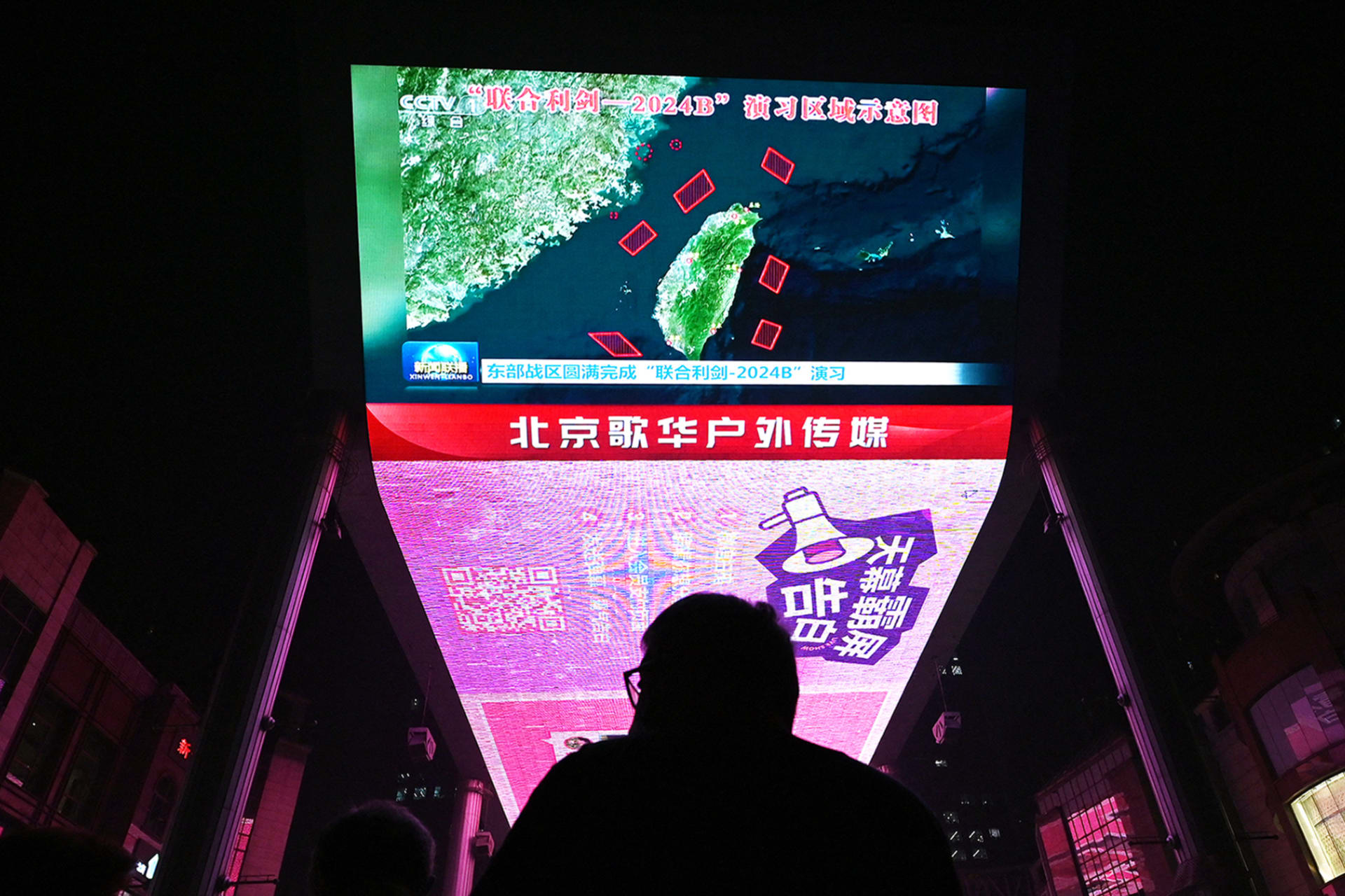 <p>A man in Beijing watches a news program about Chinese military drills surrounding Taiwan.</p>
