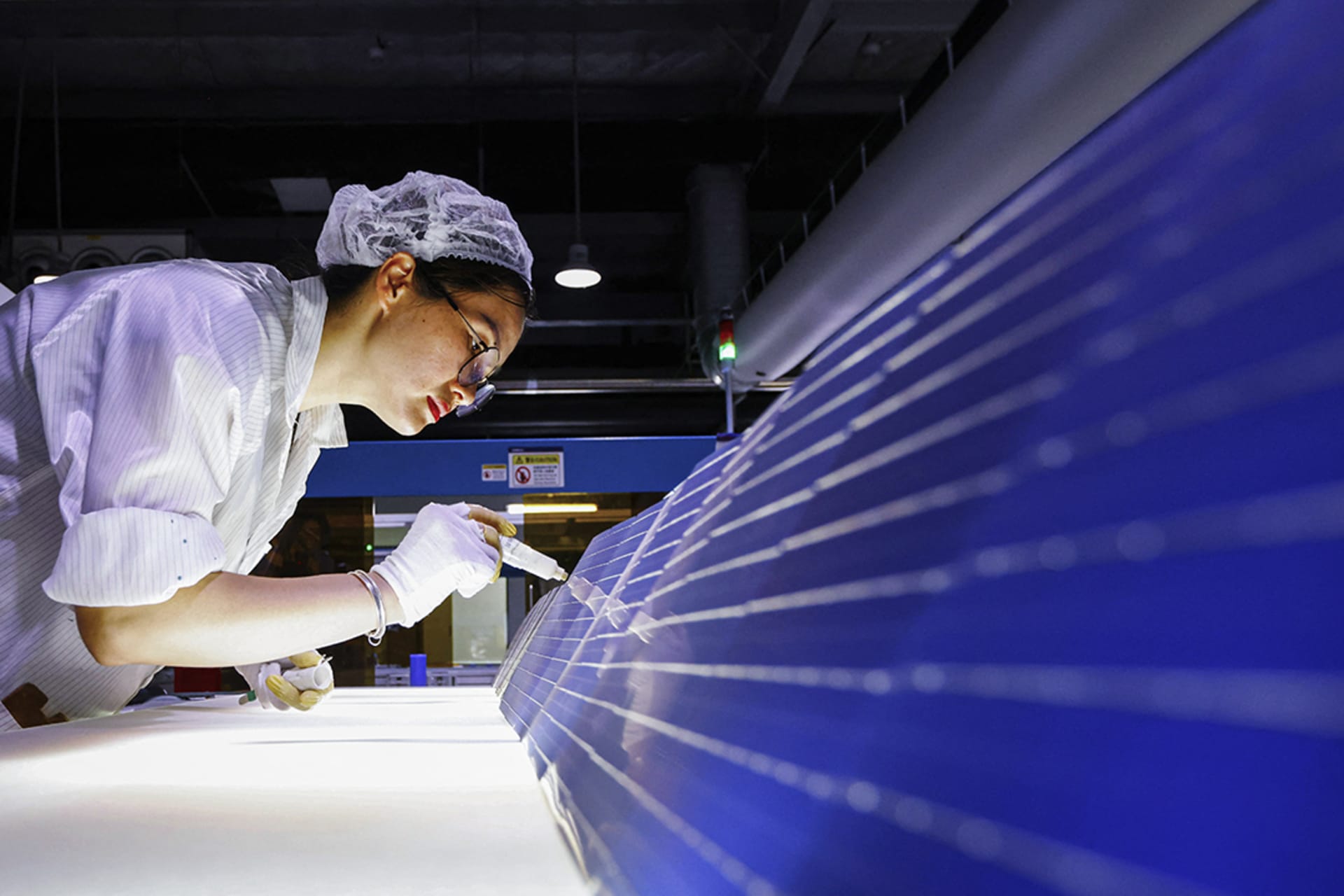 <p>An employee works on photovoltaic modules destined for export at a factory in Sihong, China, on Sept. 3.</p>
