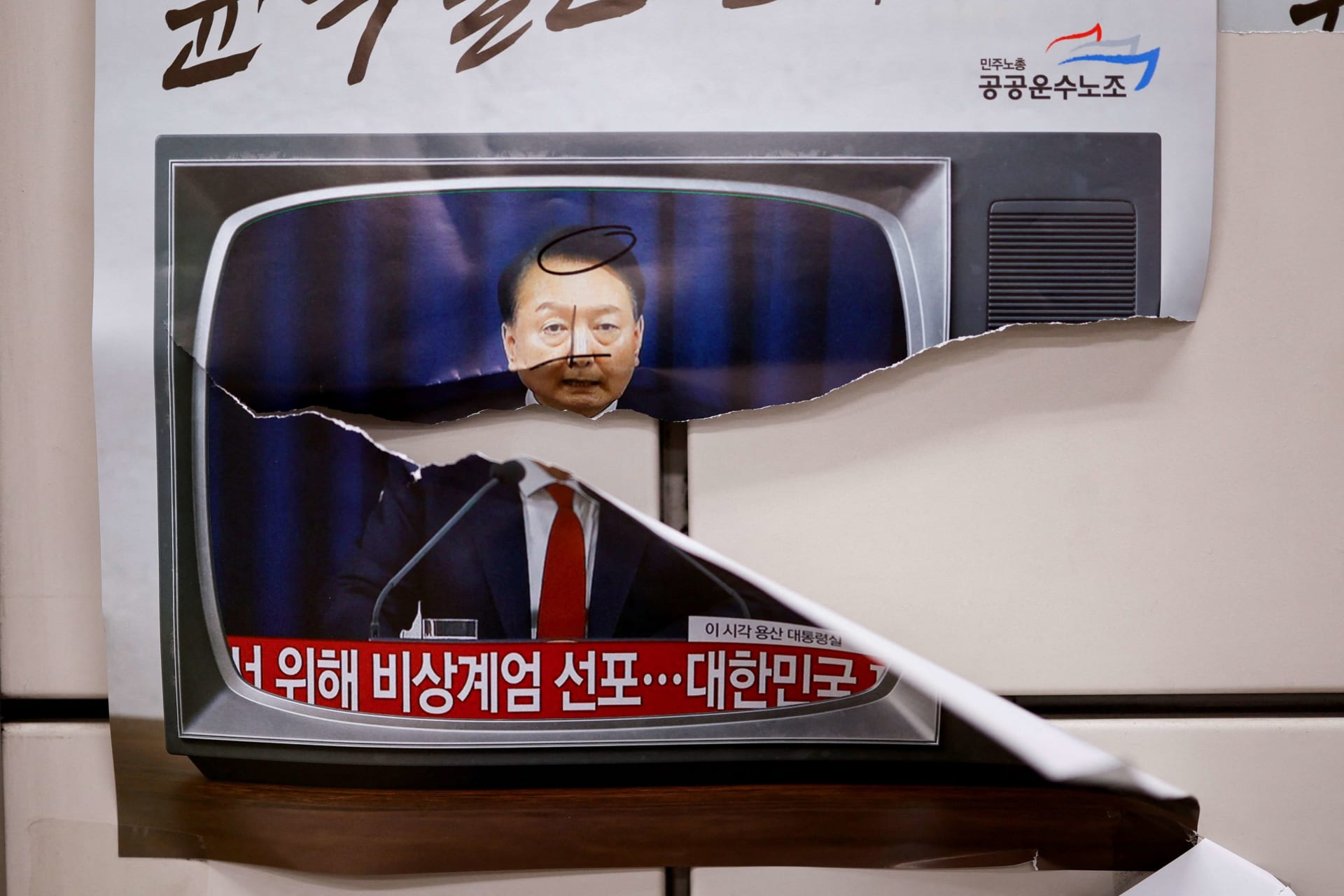 <p>A person passes by placards with images of South Korean President Yoon Suk Yeol on the day of a rally calling for the impeachment of South Korean President Yoon Suk Yeol, who declared martial law, which was reversed hours later, near the National Assembly</p>
