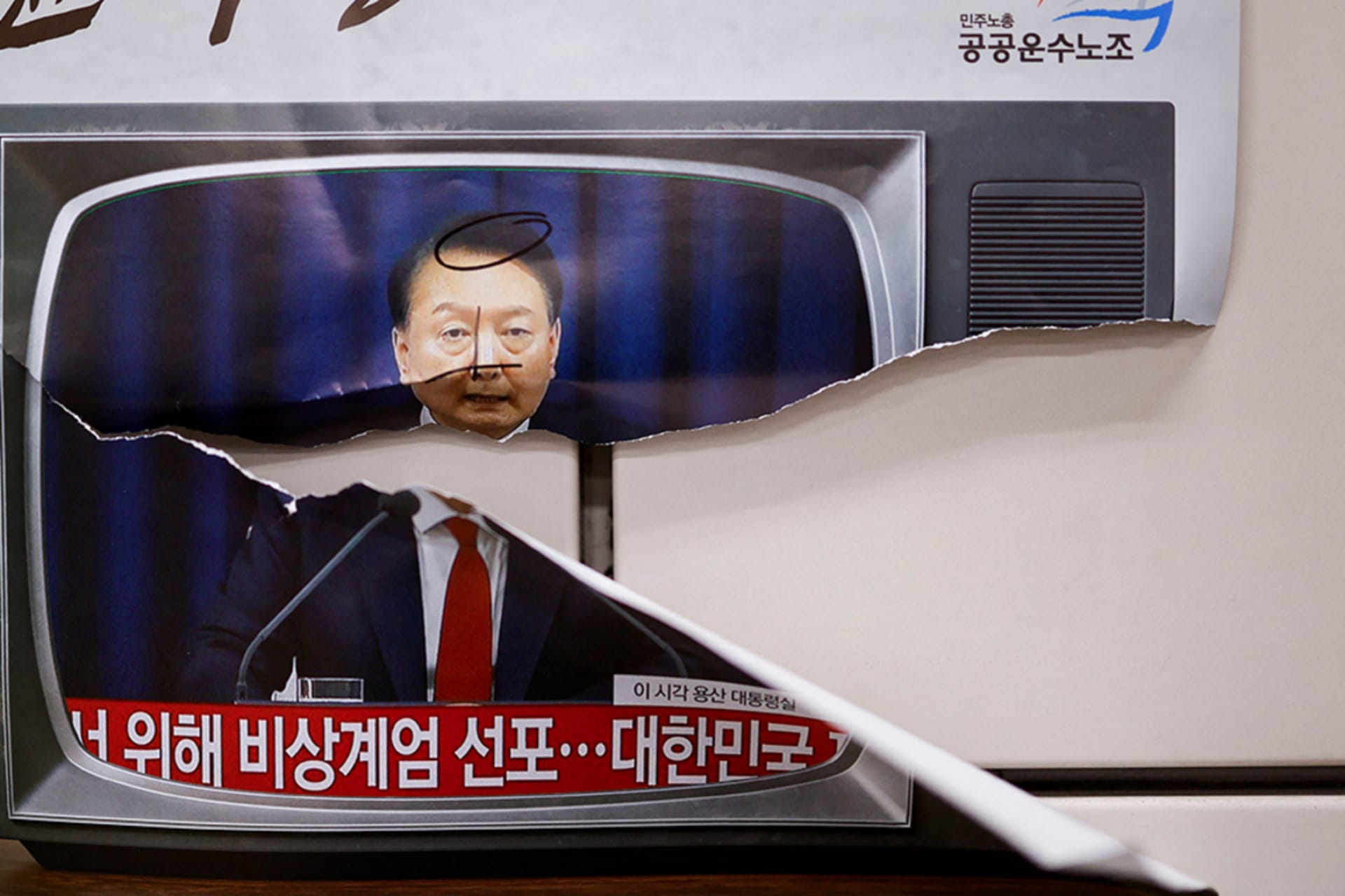 <p>A ripped image of South Korean President Yoon Suk Yeol is plastered to a wall on the day of a rally calling for his impeachment.</p>
