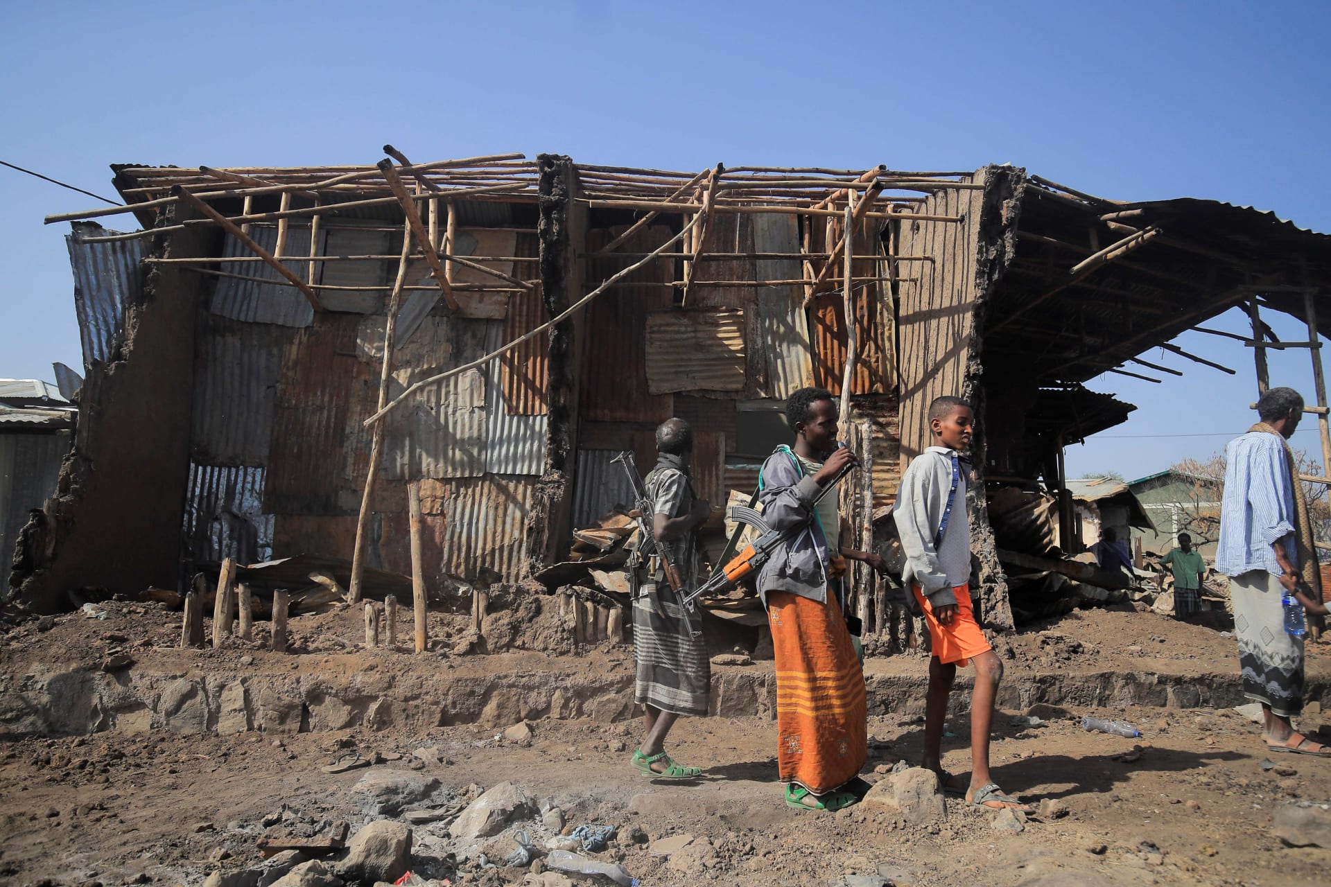 <p>Residents and militias stand next to houses destroyed by an airstrike during the fight between the Ethiopian National Defence Forces (ENDF) and the Tigray People’s Liberation Front (TPLF) forces in Kasagita, Ethiopia, on February 25, 2022. </p>
