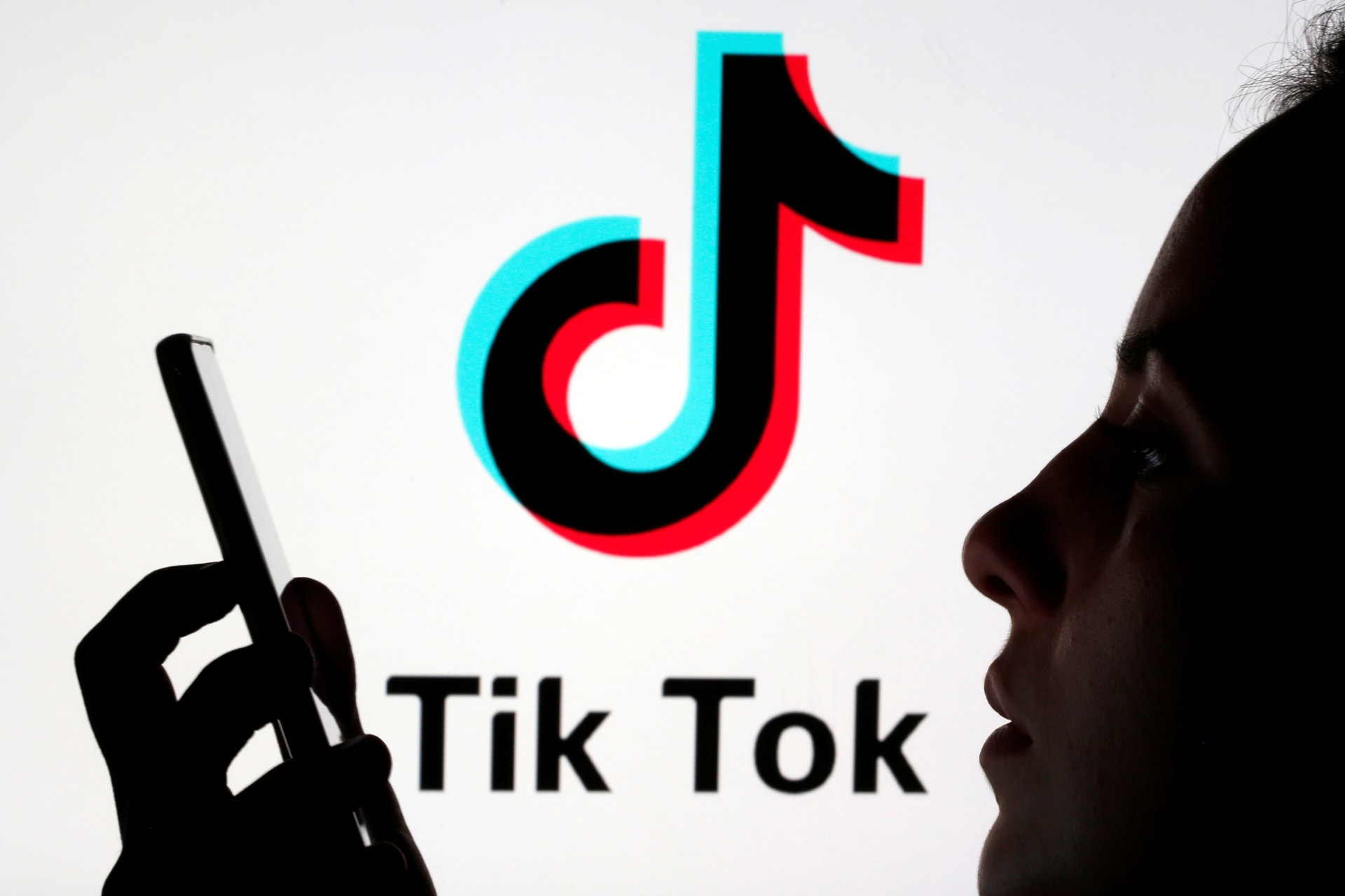 <p>A person holds a smartphone as Tik Tok logo is displayed behind in this picture illustration taken November 7, 2019.</p>
