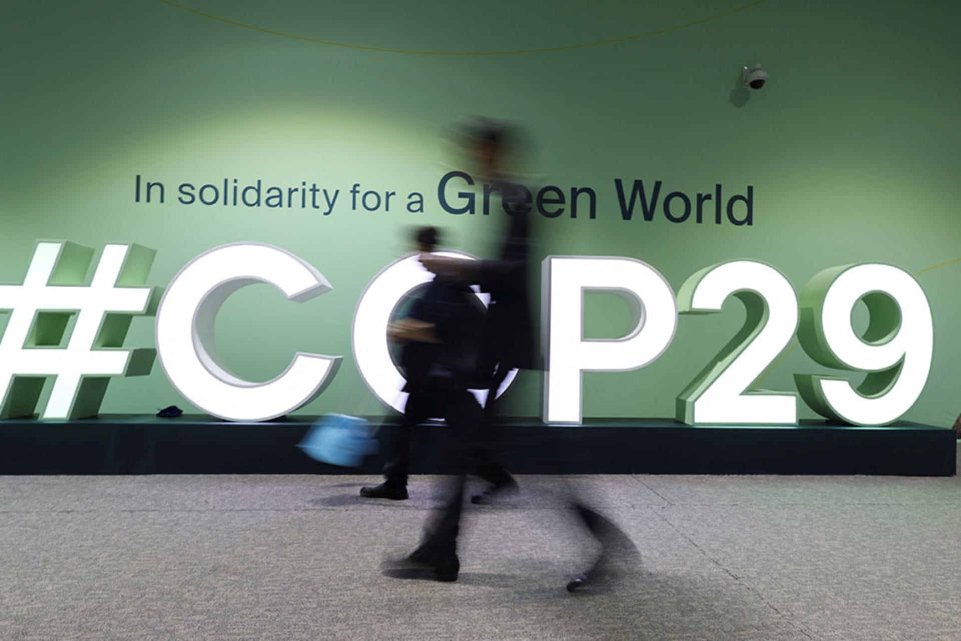 <p>People walk past a COP29 logo during the United Nations Climate Change Conference (COP29), in Baku, Azerbaijan.</p>
