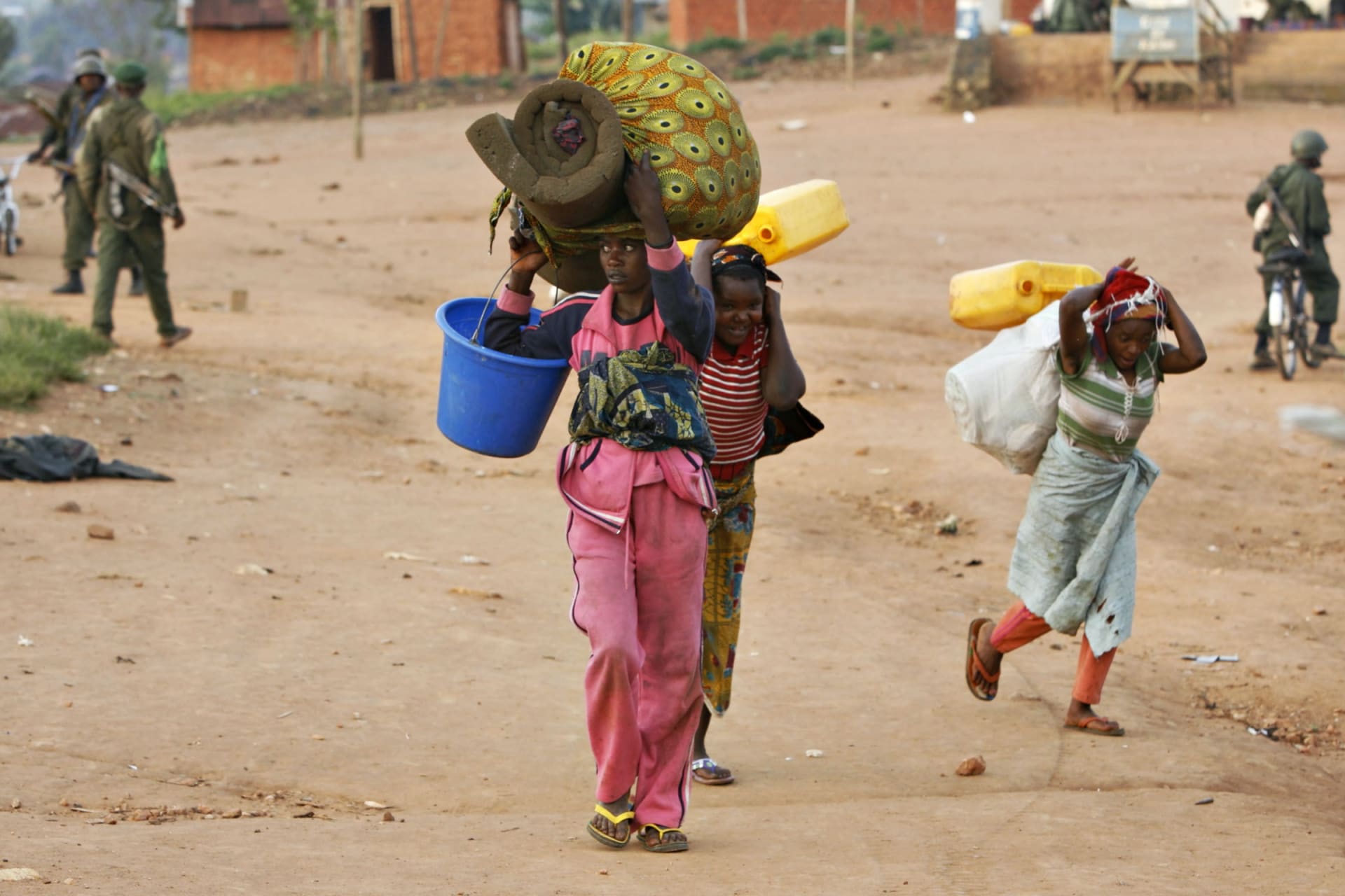 <p>Women carry belongings on their heads while government soldiers loot homes and shops after a day of fighting in the village of Kayna in eastern Congo, November 18, 2008.</p>
