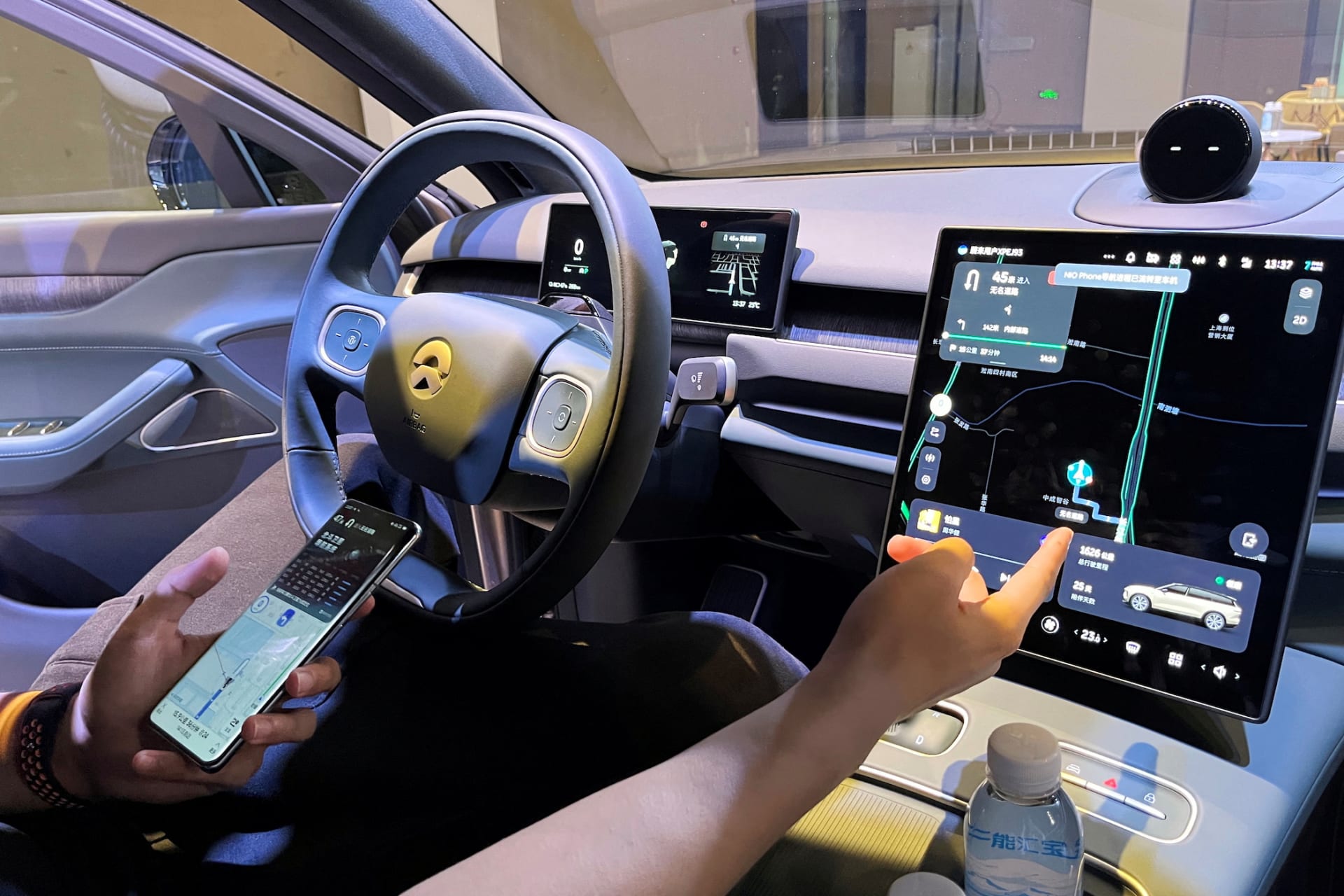 <p>A staff member of the Chinese electric vehicle maker Nio demonstrates to media members a phone’s connectivity to a car during an expo in Shanghai, China.</p>
