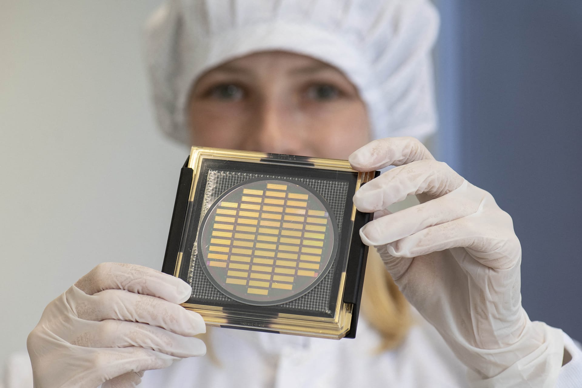 <p>An engineer shows a wafer with photonic chips for quantum computing at the company Q.ANT.</p>
