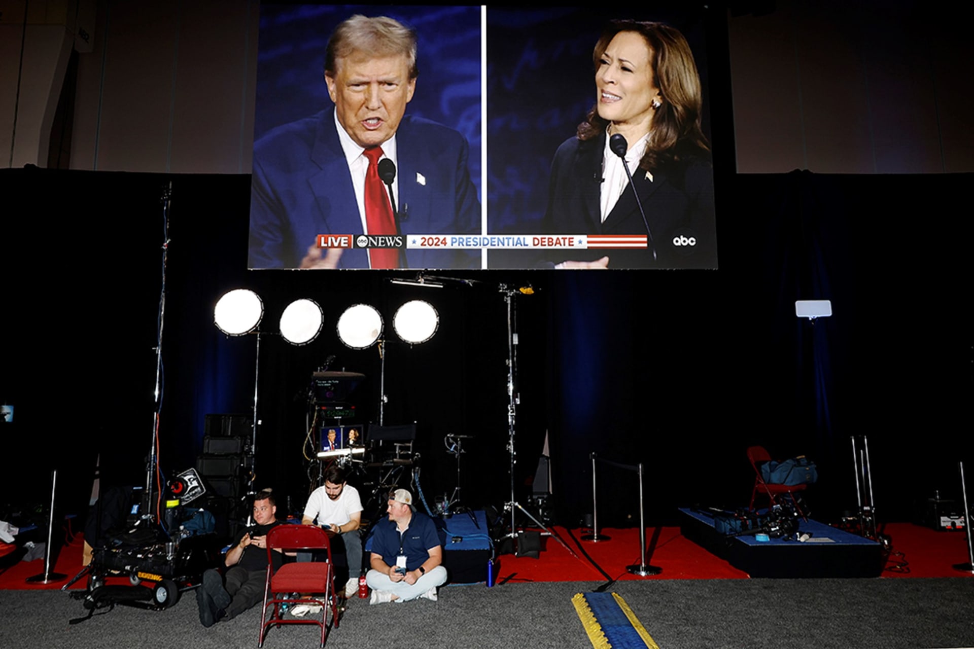 <p>Donald Trump and Kamala Harris are seen on a screen at the Pennsylvania Convention Center on September 10, 2024</p>