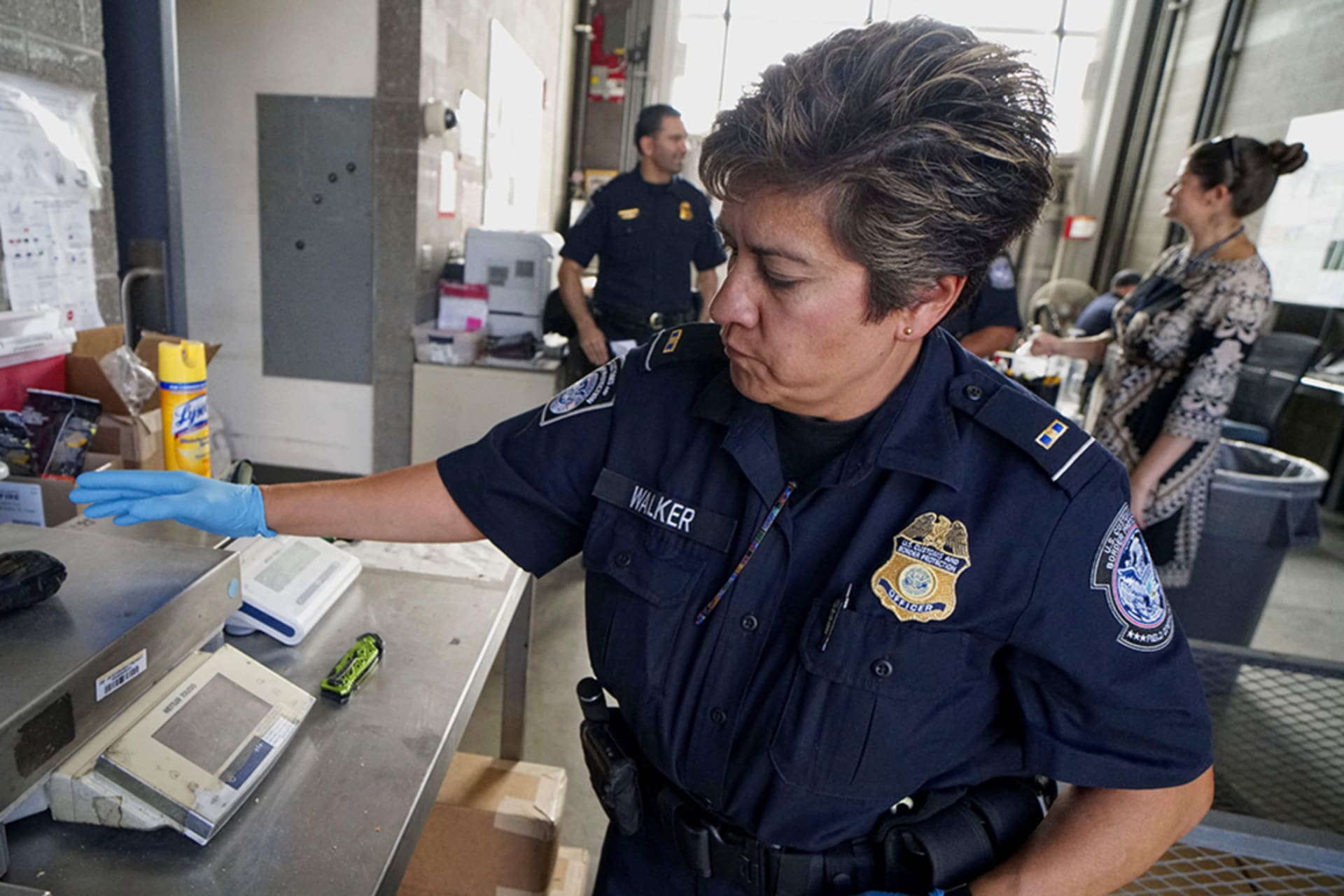 <p>A U.S. Customs and Border Protection officer weighs a package of fentanyl in San Ysidro, California.</p>
