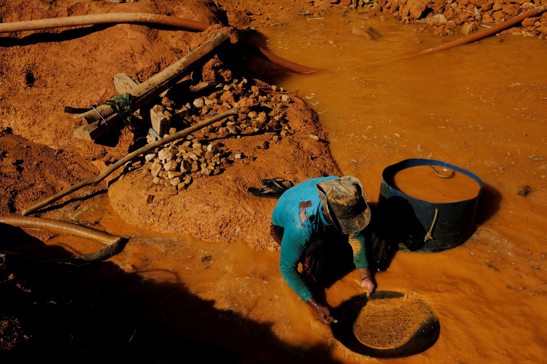 <p>A Brazilian wildcat miner, or garimpeiro, pans for gold at a wildcat gold mine in a deforested area of the Amazon rainforest.</p>
