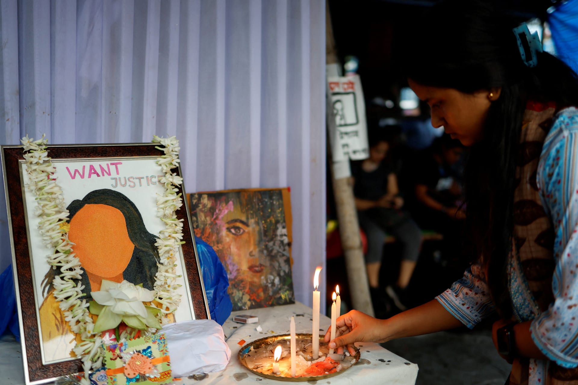 <p>A woman lights a candle as she attends a protest condemning the rape and murder of a trainee medic, inside the premises of R G Kar Medical College and Hospital in Kolkata, India, August 20, 2024. </p>
