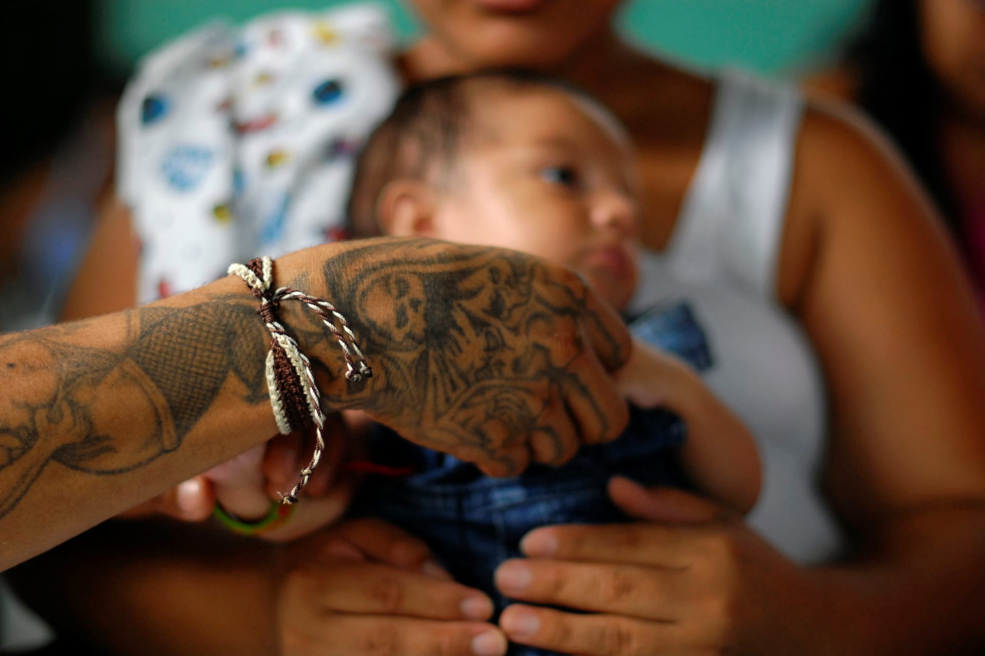 <p>A gang member and inmate plays with his son, who is being carried by his partner, in a prison in Quetzaltepeque, on the outskirts of San Salvador June 16, 2012. </p>
