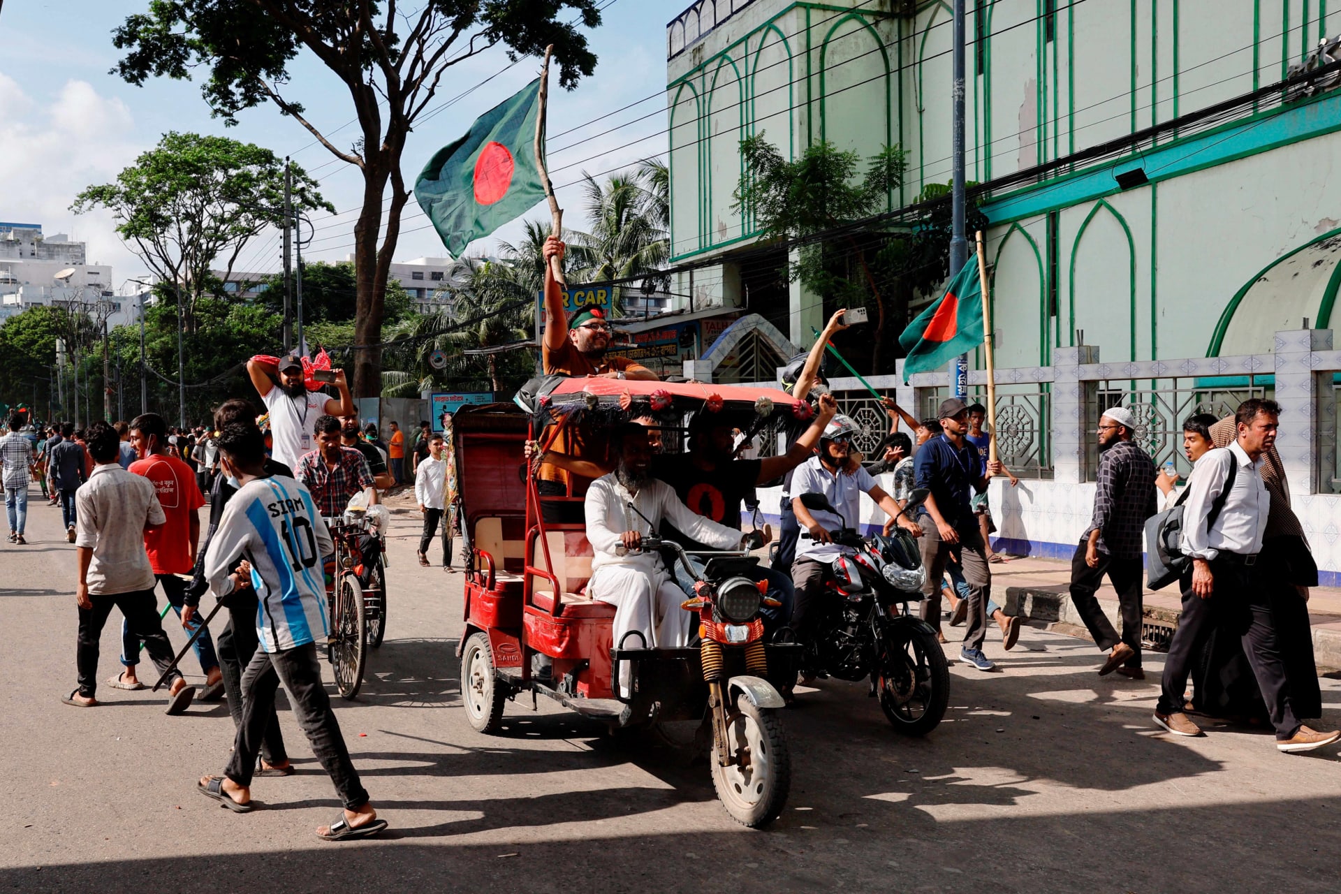 <p>People wave Bangladeshi flags as they celebrate the resignation of Prime Minister Sheikh Hasina in Dhaka, Bangladesh, on August 5, 2024.</p>
