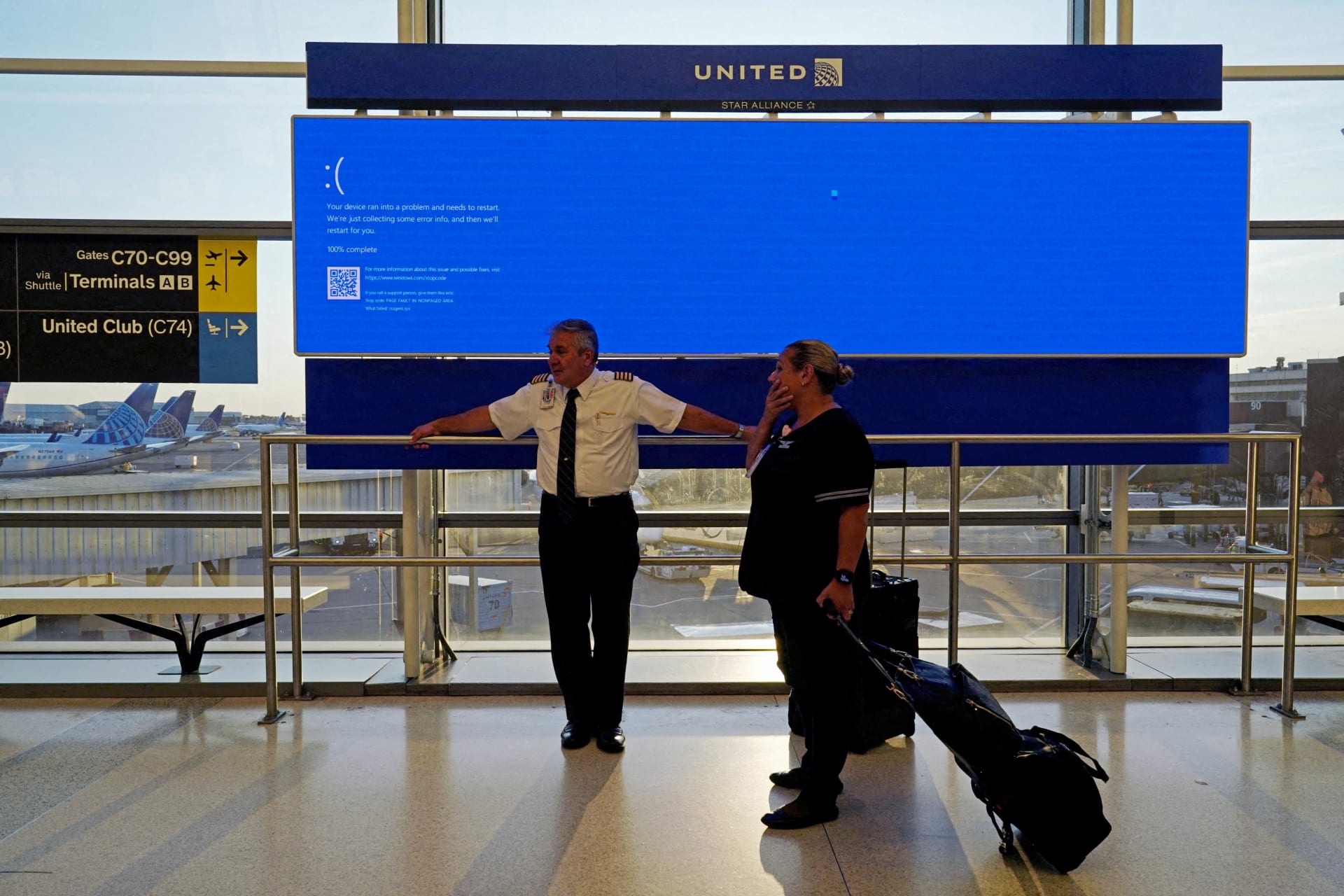 <p>United Airlines employees wait by a departures monitor displaying a blue error screen, also known as the “Blue Screen of Death” inside Terminal C in Newark International Airport caused by an update to CrowdStrike’s “Falcon Sensor” software.</p>
