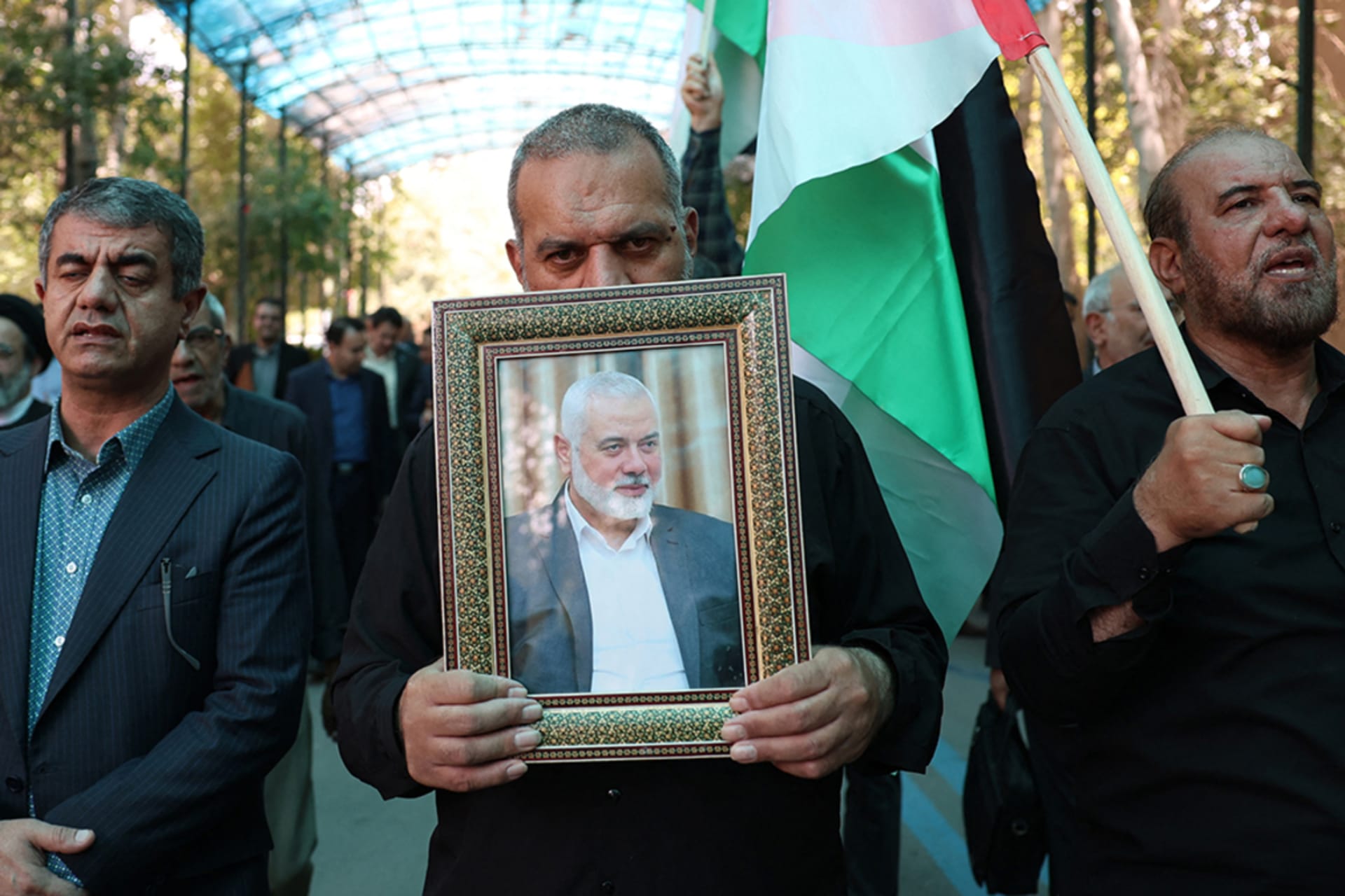 <p>People hold up the Palestinian flag and a portrait of assassinated Hamas political leader Ismail Haniyeh in Tehran, Iran.</p>
