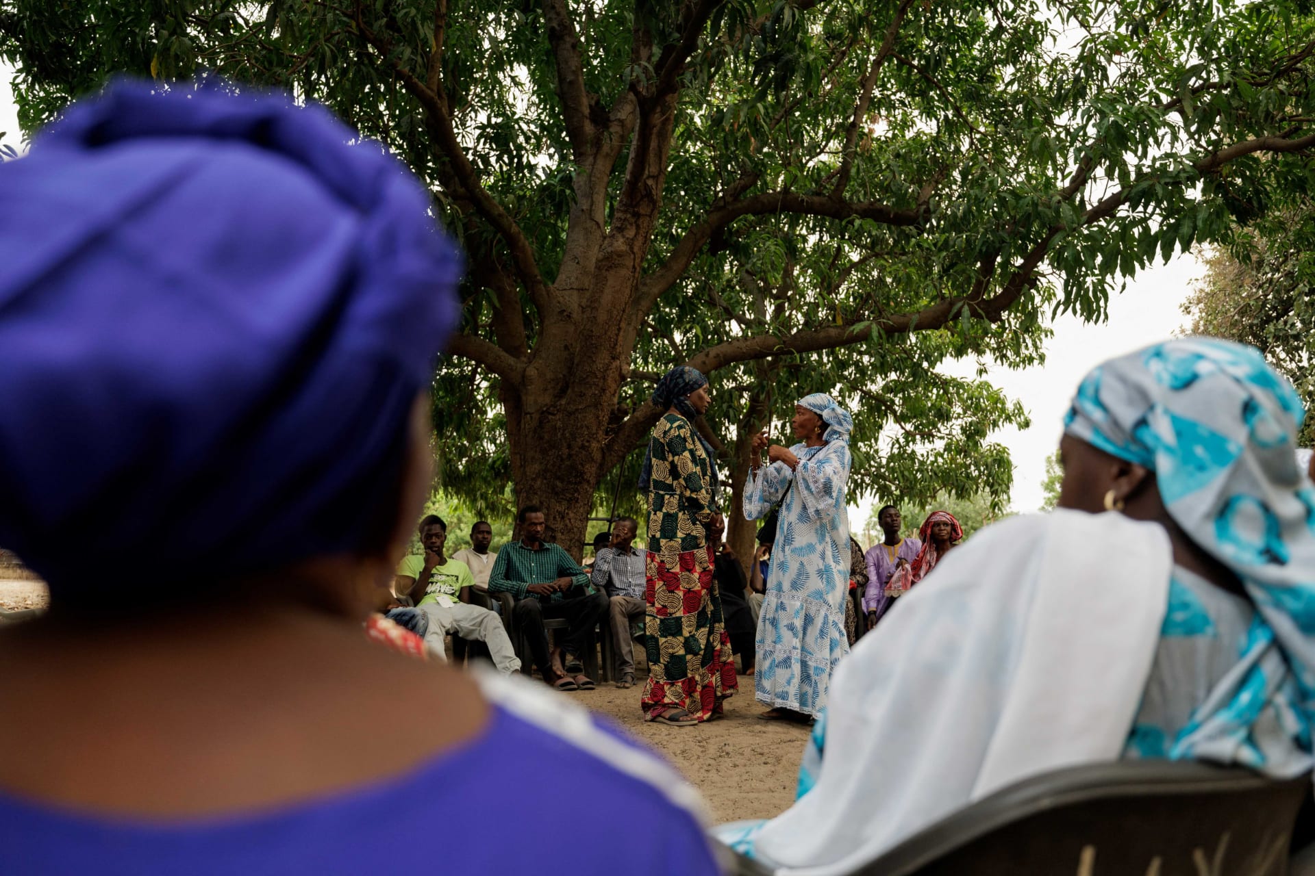 <p>Gambian activist Fatou Baldeh listens to Fatou Ba, as she mediates a discussion about female genital mutilation (FGM) involving women and a handful of men sitting under a mango tree in Sintet, Gambia, June 8, 2024.</p>
