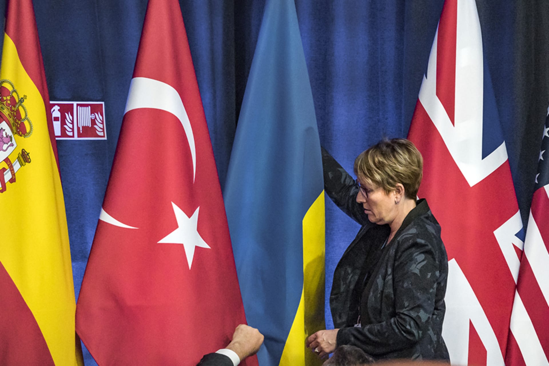 <p>An assistant puts a Ukrainian flag among the flags of the NATO members inside the NATO Council during the 2023 summit in Vilnius, Lithuania. </p>
