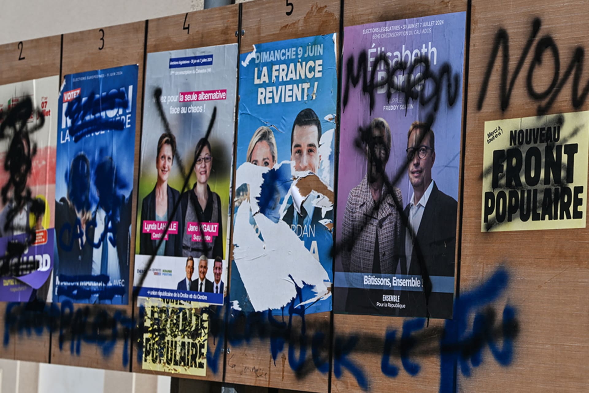 <p>Vandalized posters are pasted to a wall in northwestern France ahead of French elections in June 2024.</p>
