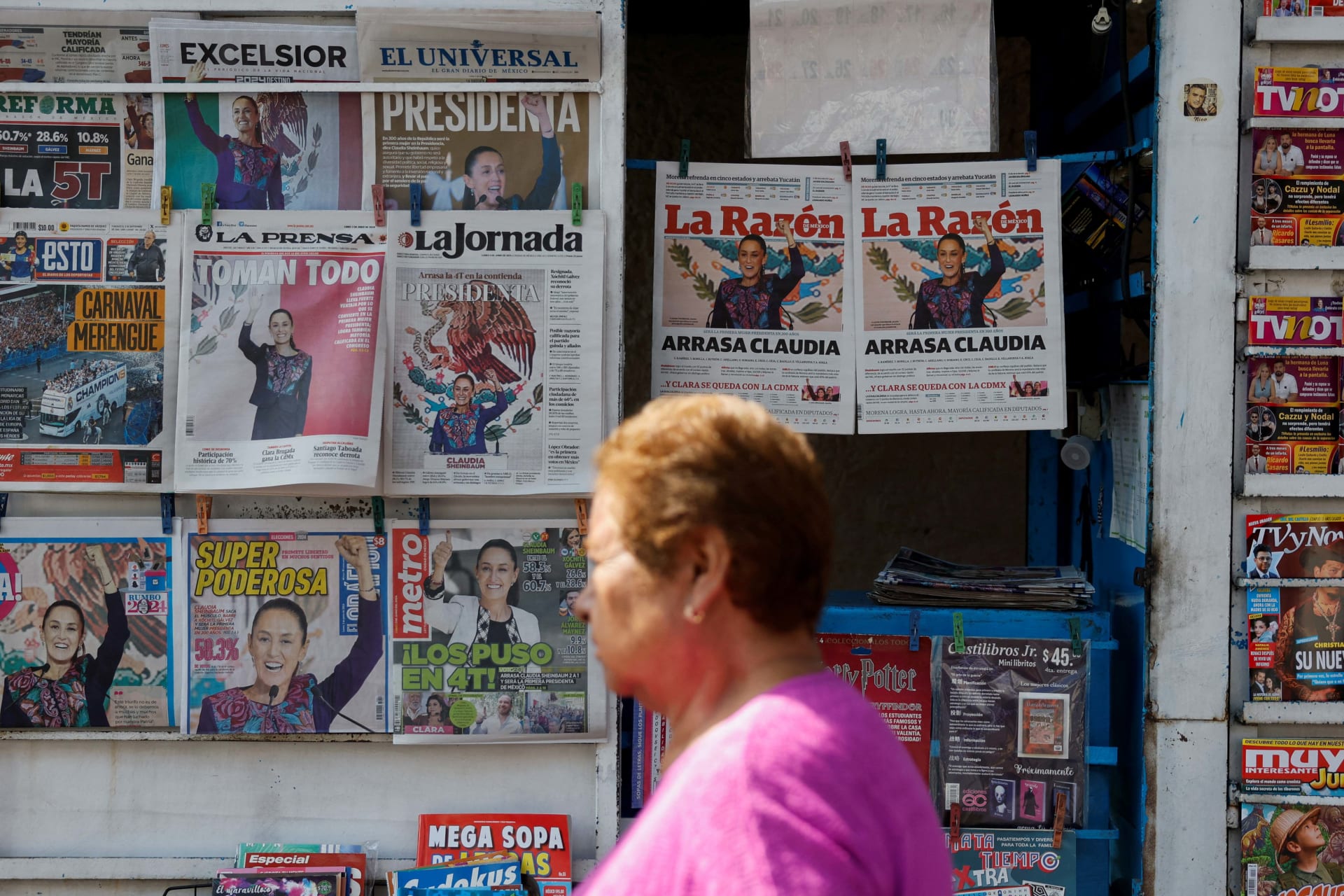 <p>A woman walks past newspapers displaying the victory of the presidential candidate of the ruling Morena party Claudia Sehinbaum, a day after the general election, in Mexico City, Mexico June 3, 2024. </p>

