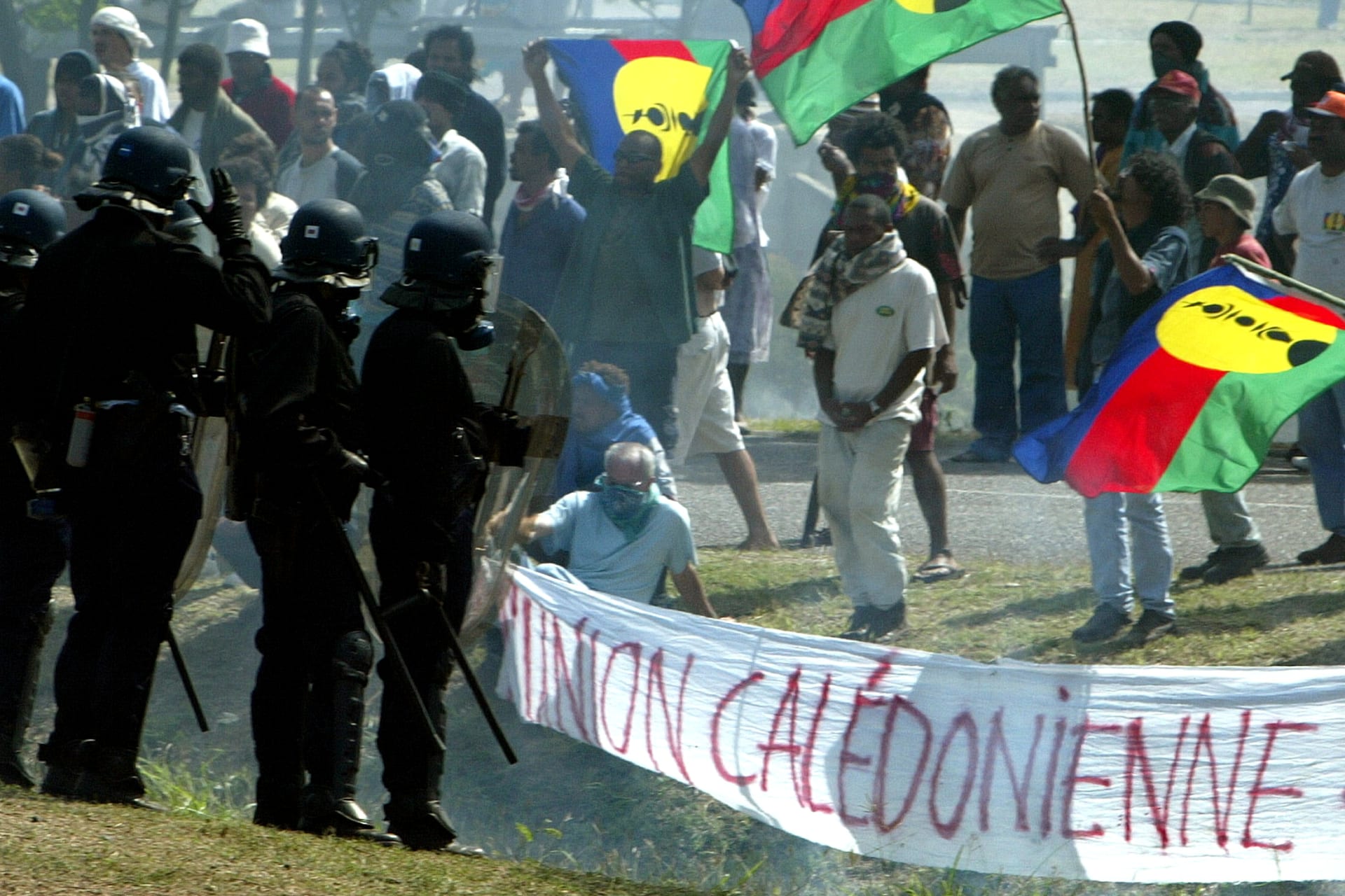 <p>Pro-independance demonstrators hold a Kanak flags as they face French riot police during a protest outside the New Caledonian northern province assembly while French President Jacques Chirac was paying a visit to the New Caledonian northern city of Kone o</p>
