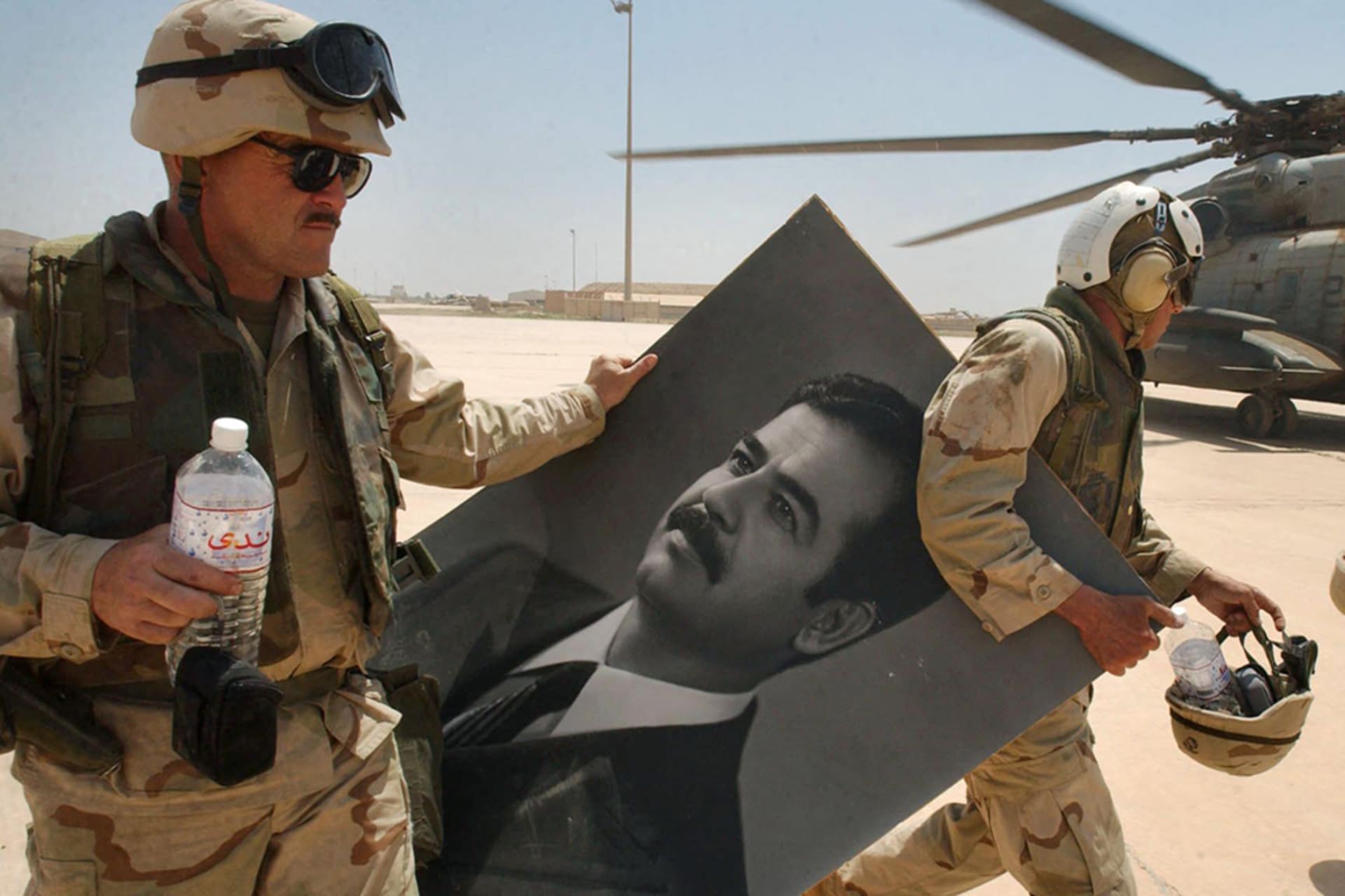 <p>U.S. Marines carry a portrait of toppled Iraqi President Saddam Hussein at Baghdad’s international airport in April 2003.  </p>

